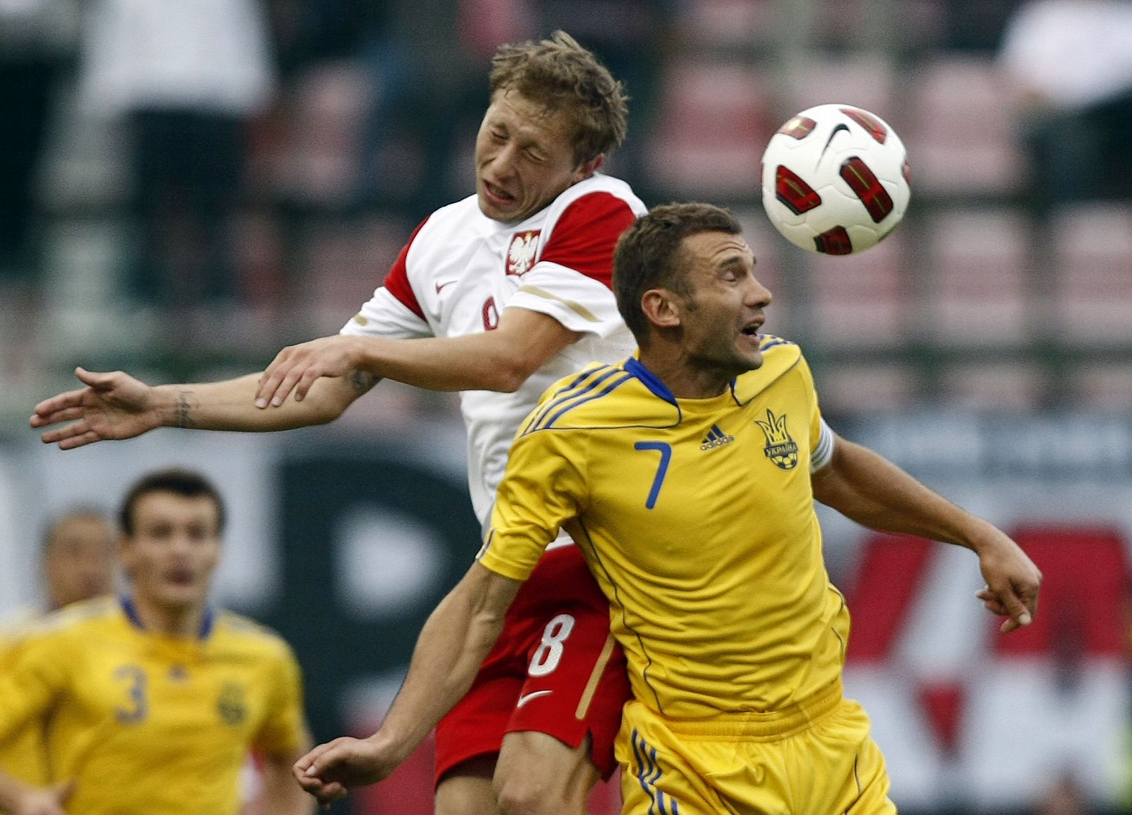 Murawski of Poland jumps for the ball against Shevchenko of Ukraine team during their friendly soccer match in Ludz