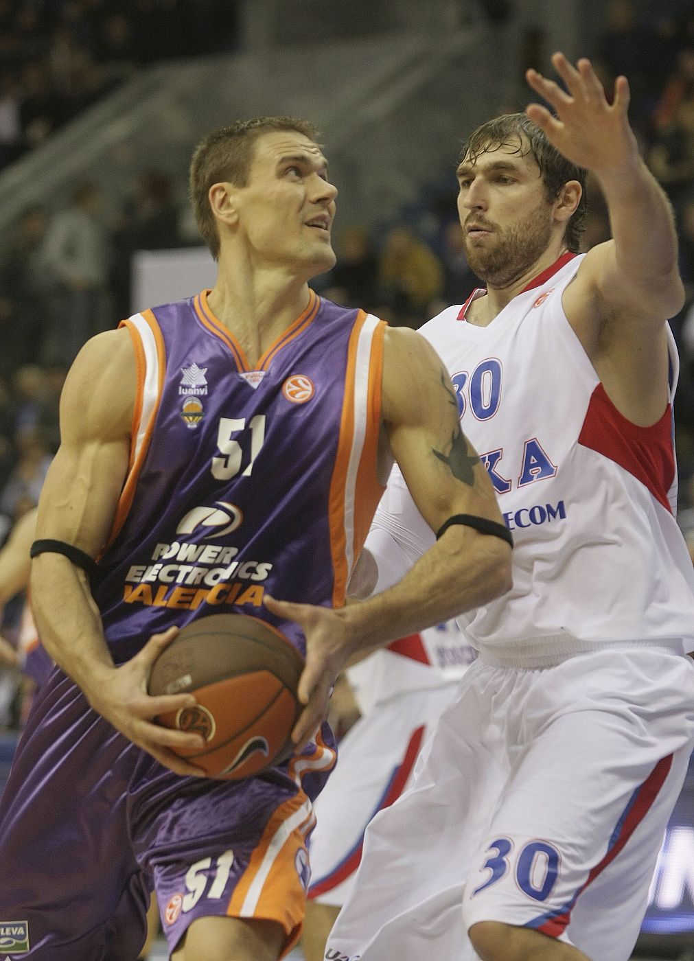 El jugador del Power Electronics Valencia, Robertas Javtokas conduce el balón hacia la canasta mientras el jugador del CSKA de Moscú, Dmitri Sokolov.