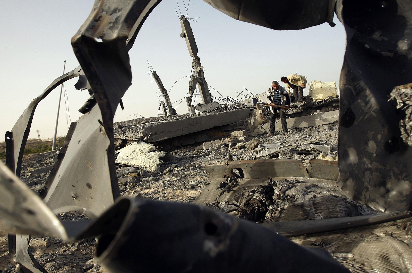 Dos palestinos buscando entre escombros en Khan Younis, al sur de Gaza, tras un ataque aéreo israelí