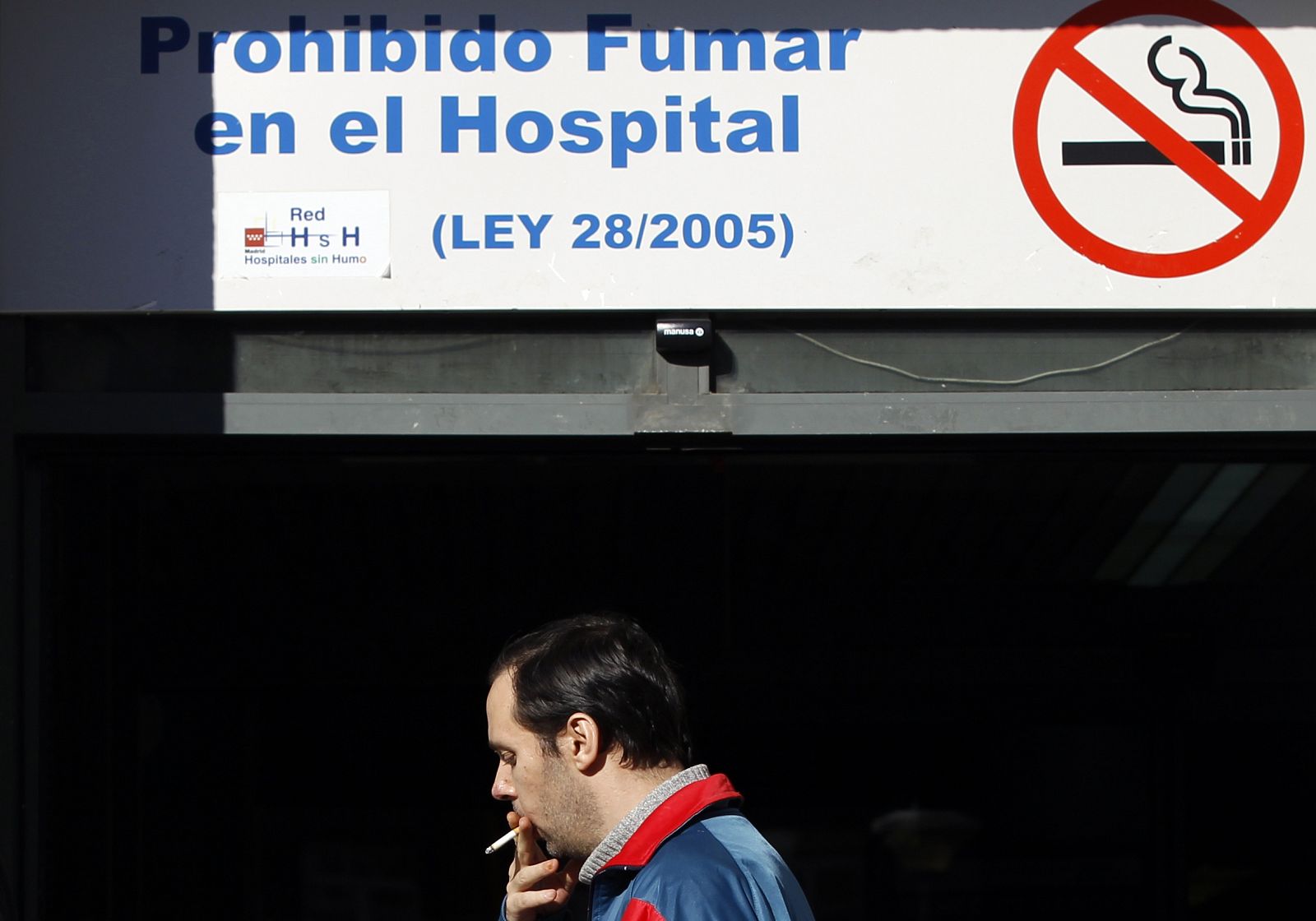 Un hombre fumando un cigarrillo a la puerta del un hospital en Madrid, el pasado 1 de enero.