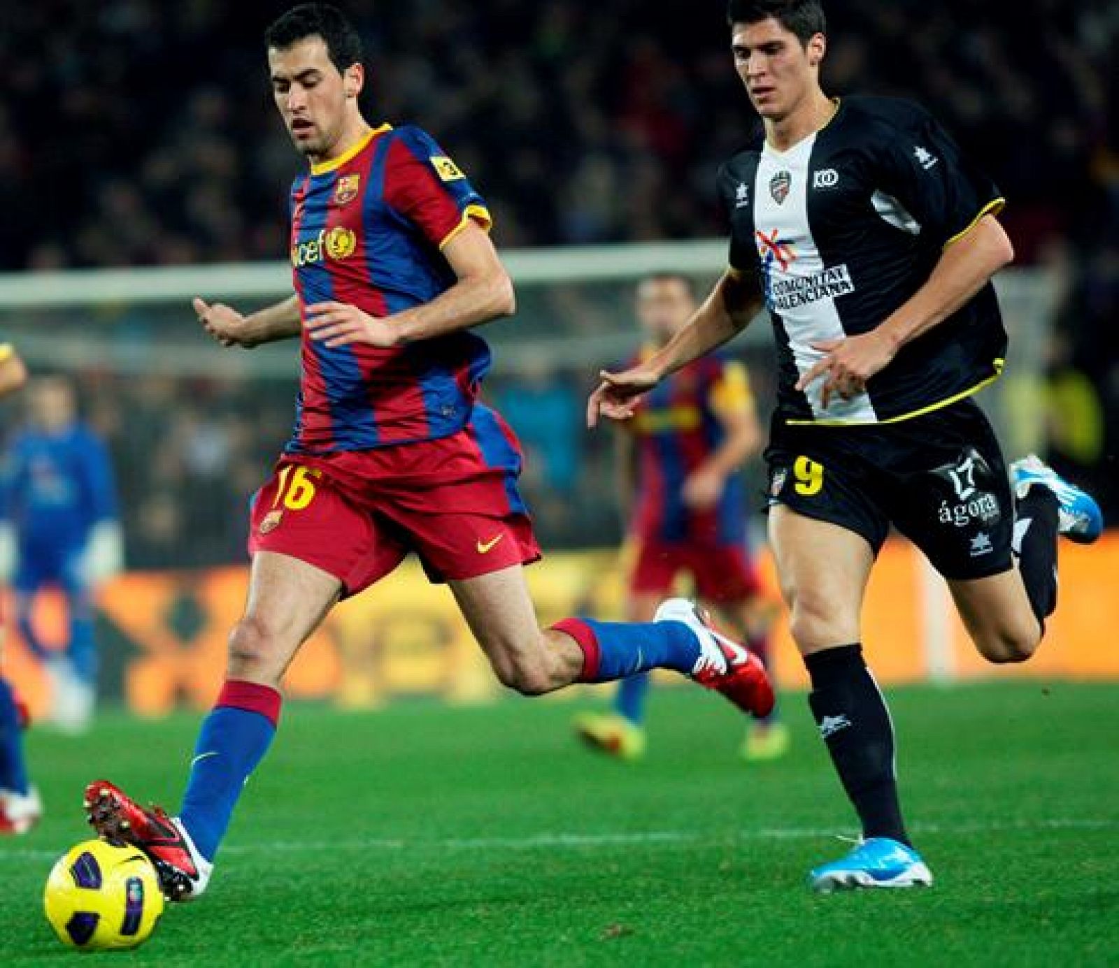 Sergio Busquets controla el balón presionado por el delantero del Levante Rafa Jordá.