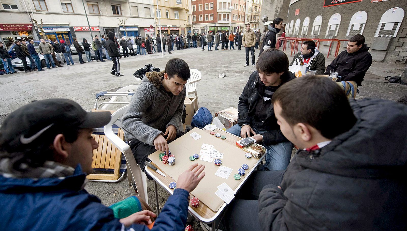 Una partida de póquer sirve a unos aficionados del Athletic para amenizar la espera por una entrada para el partido ante el Barça.