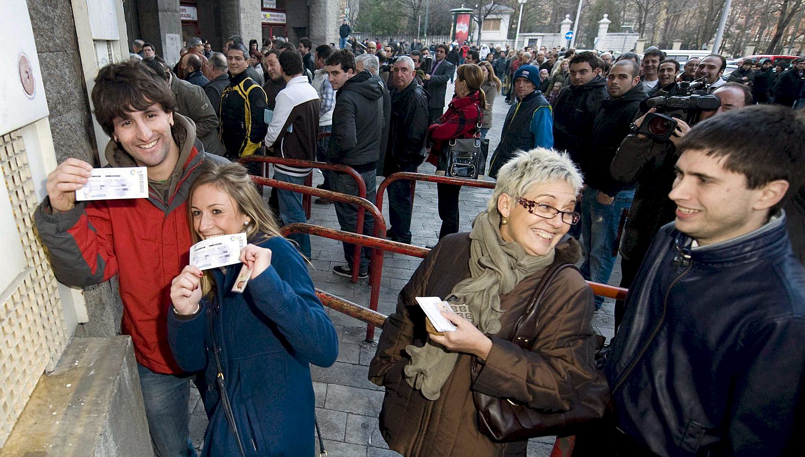 Unos aficionados sonríen tras comprar algunas de las primeras entradas que se han puesto a la venta para el partido de Copa Athletic-Barcelona.