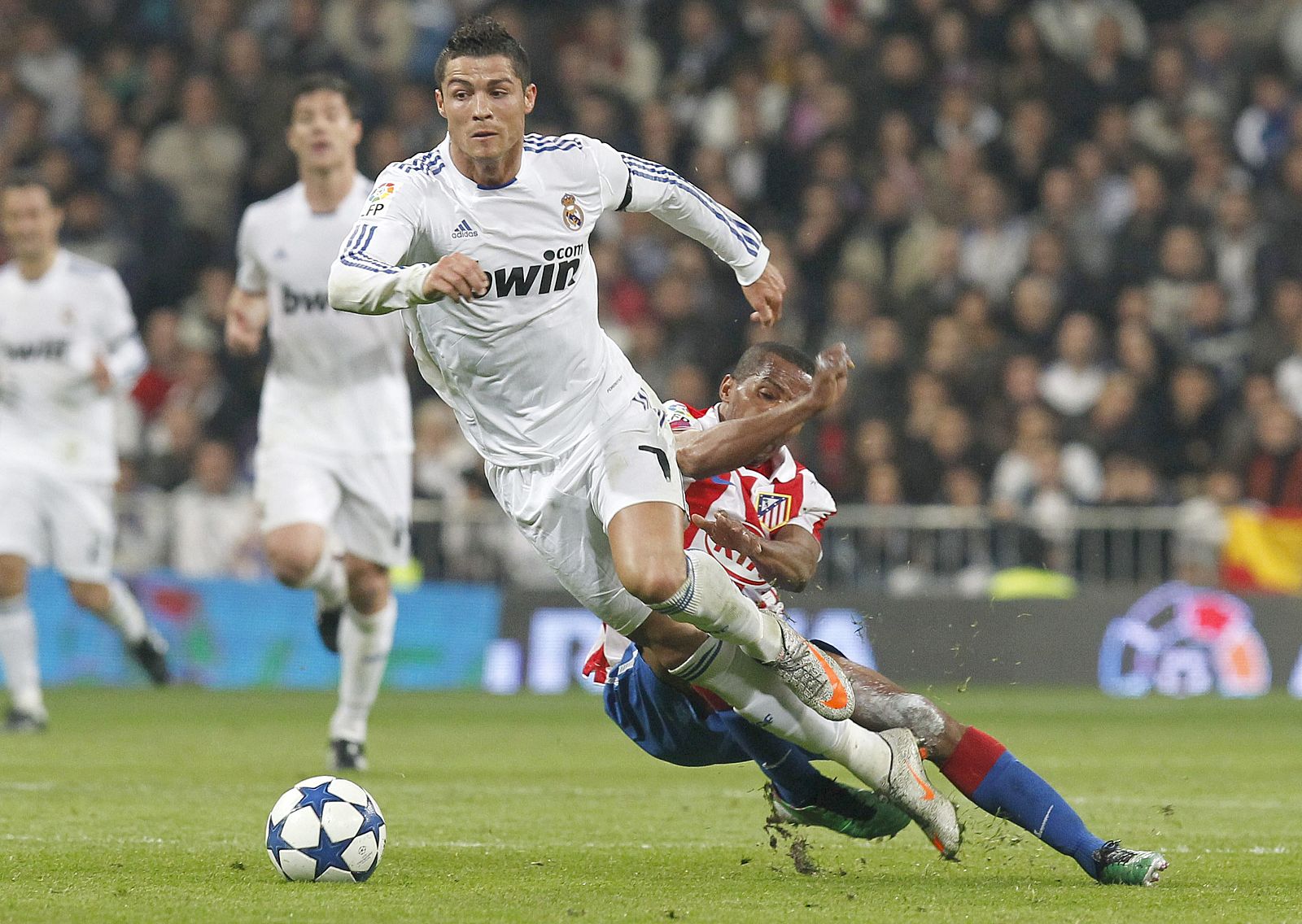 El delantero portugués del Real Madrid, Cristiano Ronaldo, intenta superar la entrada del centrocampista brasileño del Atlético de Madrid, Paulo Assuncao.