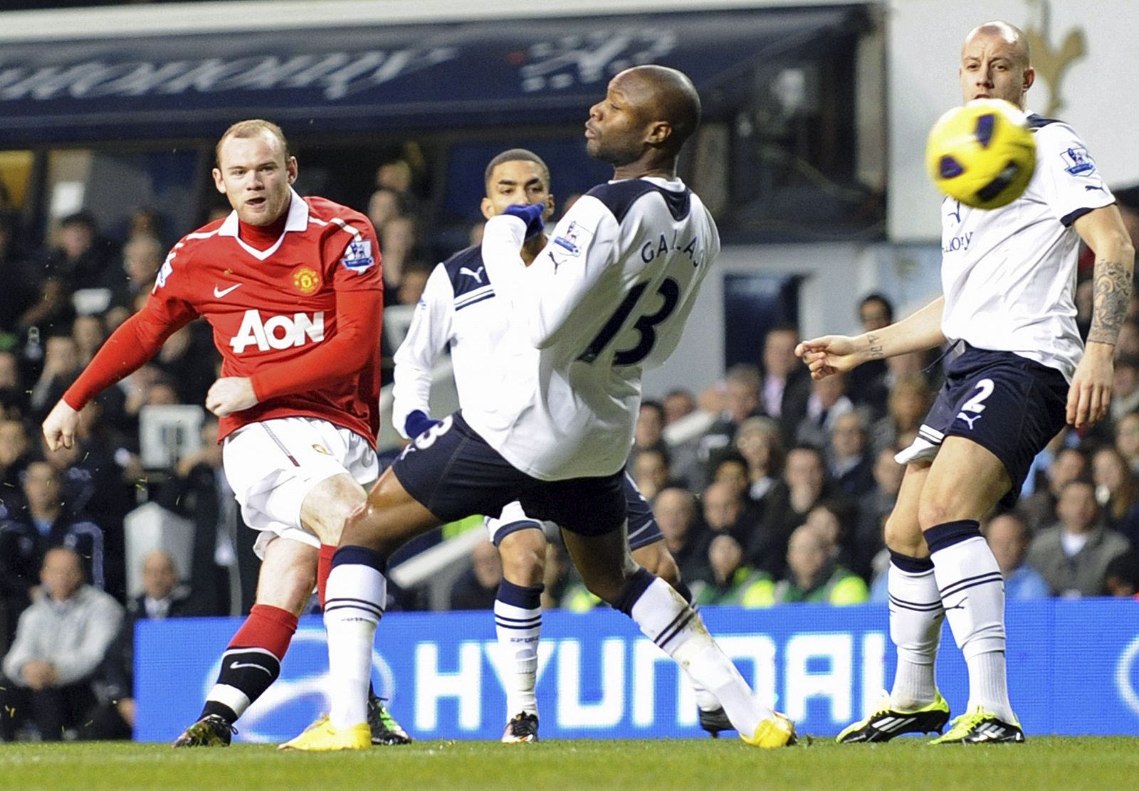 Wayne Rooney lucha por el control del balón con William Gallas.