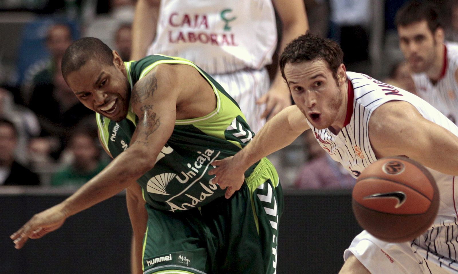 Marcelino Huertas (d) lucha por el balón con el base del Unicaja Terrell McIntyre.