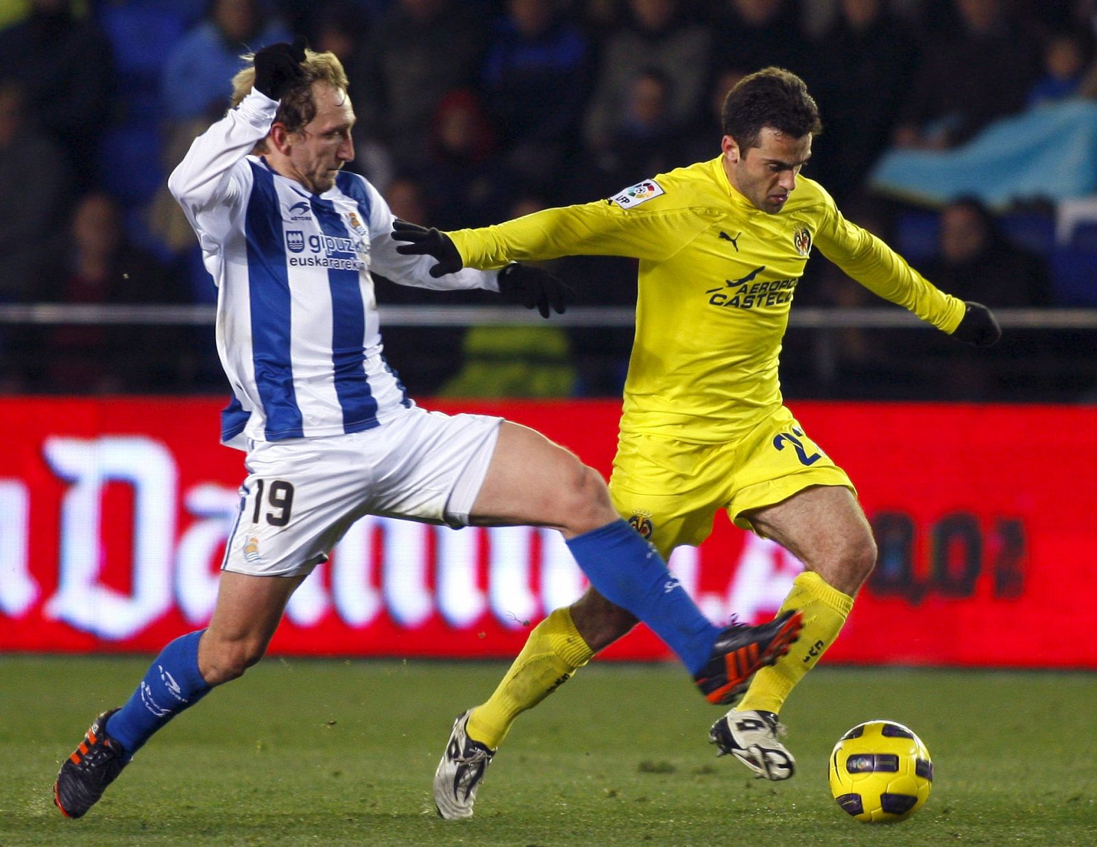 El delantero italiano del Villarreal CF Giuseppe Rossi conduce el balón presionado por el mediocentro de la Real Sociedad Diego Rivas.