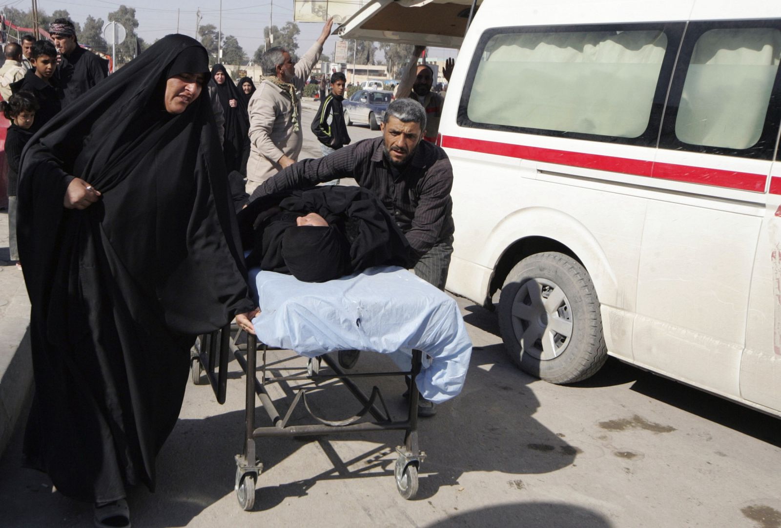 Dos personas empujan una camilla con una mujer después de un ataque con una bomba en la ciudad santa iraquí de Kerbala