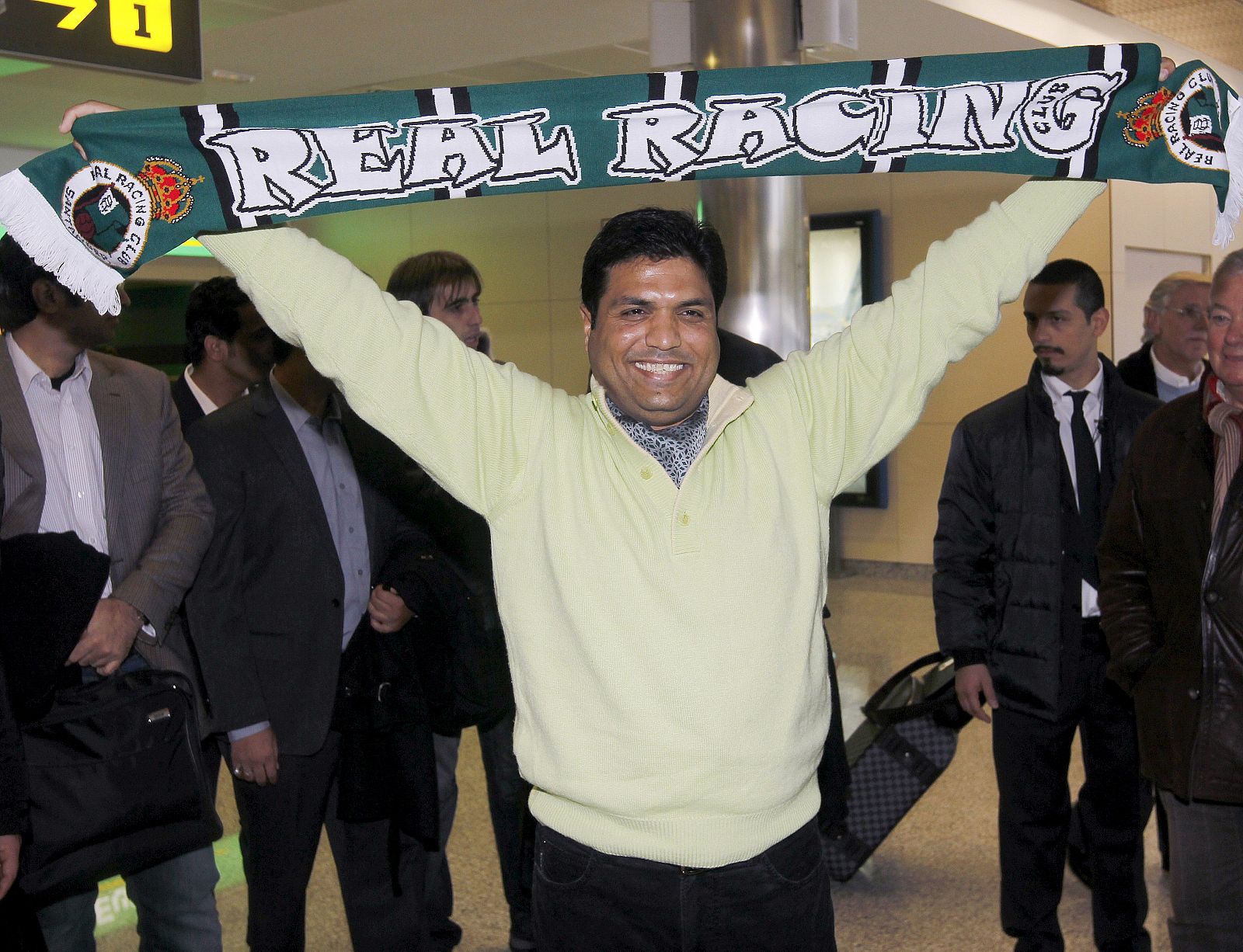 El empresario indio Ashan Ali Syed posa con una bufanda racinguista a su llegada al aeropuerto de Santander.