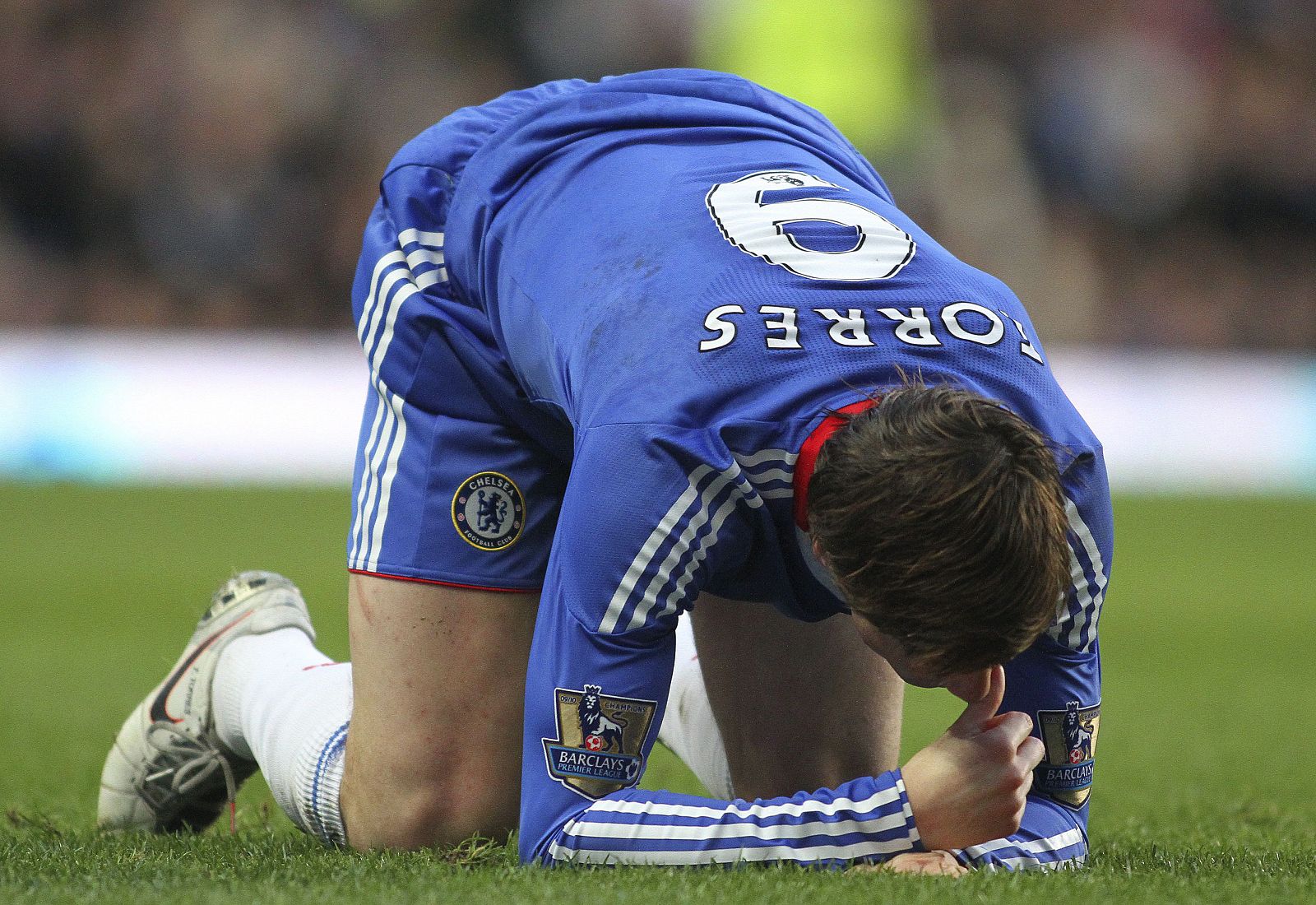 Torres arrodillado en el cesped tras un choque con Daniel Agger.