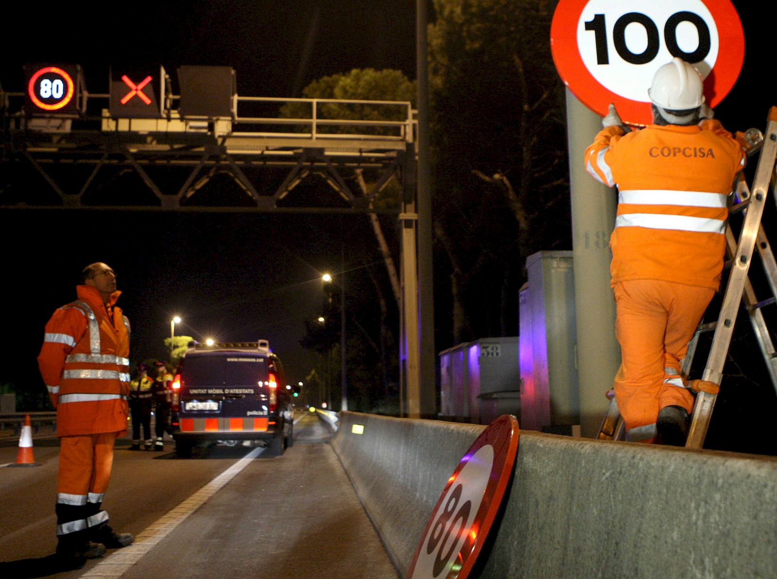 Un operario del Servicio Catalán de Tráfico cambia una señal de limitación de velocidad de 80 km/h por una de 100 km/h en Barcelona el pasado 6 de febrero