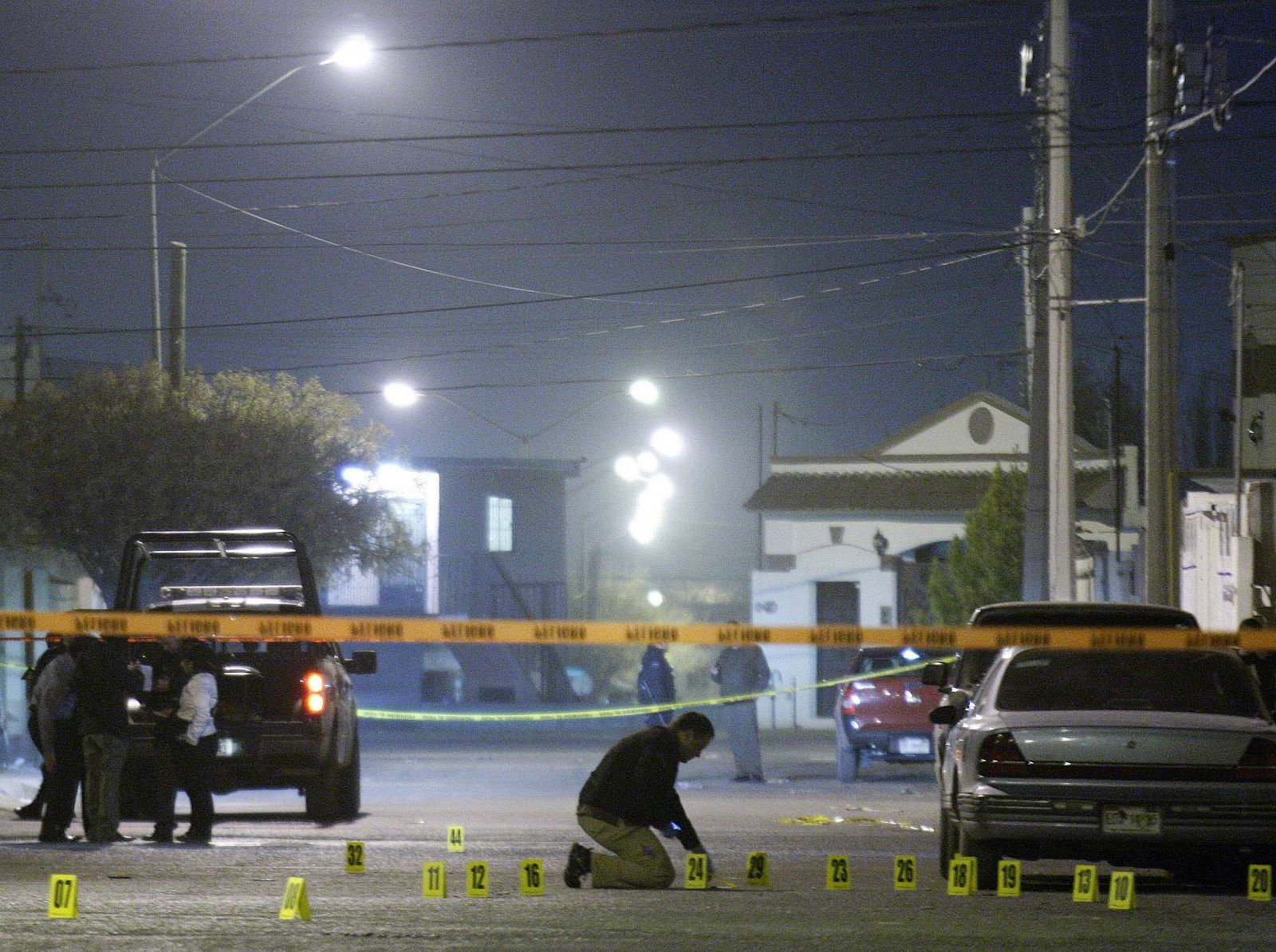 Forenses recogen pruebas en el escenario del crimen de tres mujeres en Ciudad Juárez.