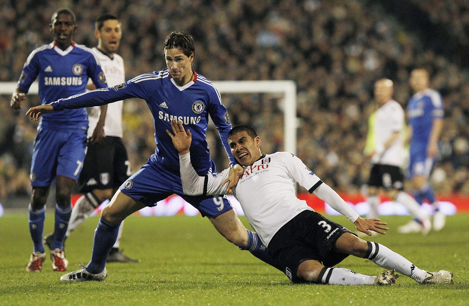 El jugador del Chelsea, Fernando Torres, recibe una falta de Carlos Salcido, del Fulham.