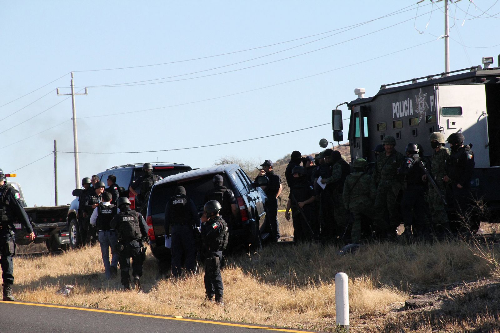 Soldiers and federal police stand around two cars of U.S. Immigration and Customs Enforcement agents in Ojo Caliente