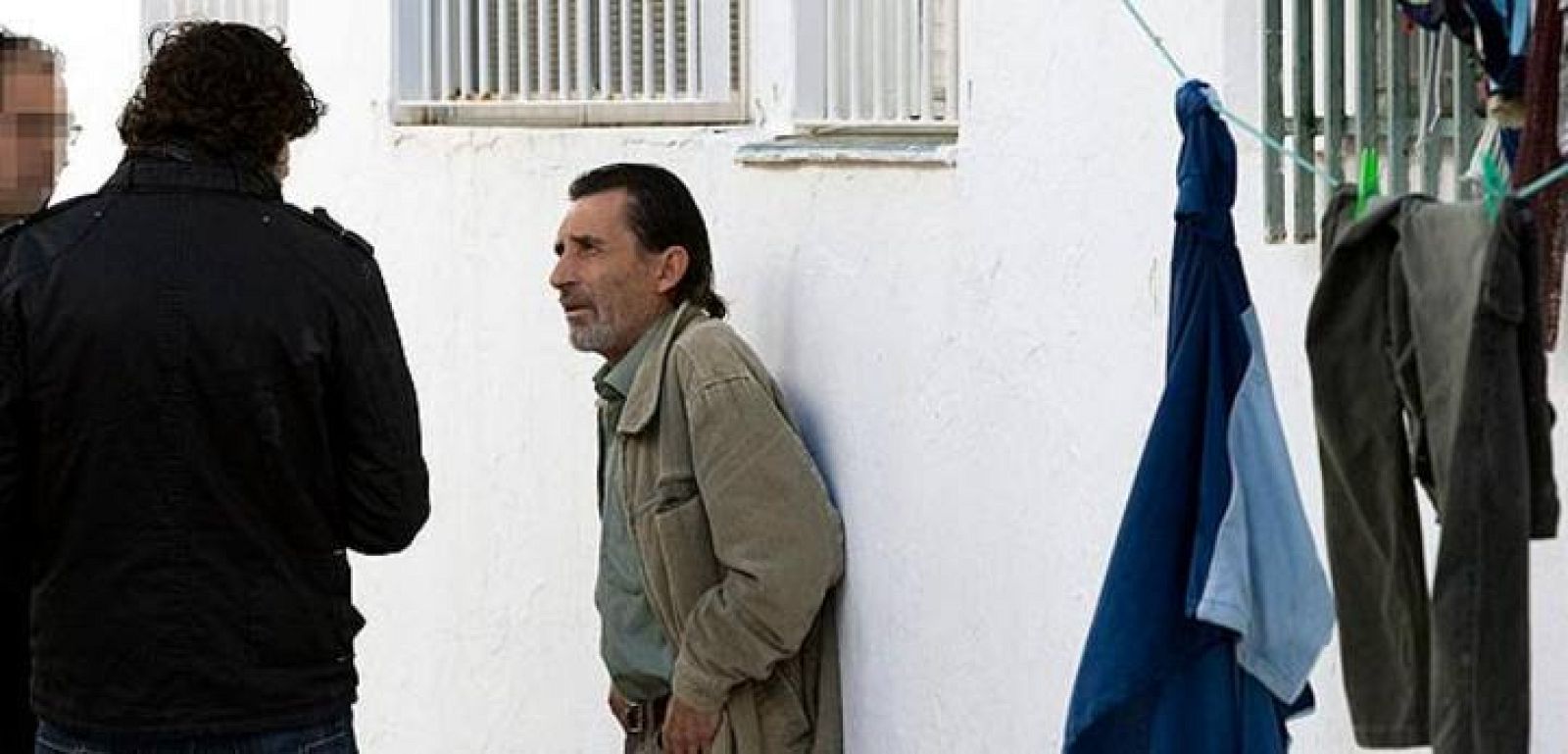  Miembros de la policía judicial hablan con el hermano del fallecido en un incendio registrado en la barriada conocida como las "200 viviendas" en el municipio almeriense de Roquetas de Mar y en el que también resultó herida una mujer