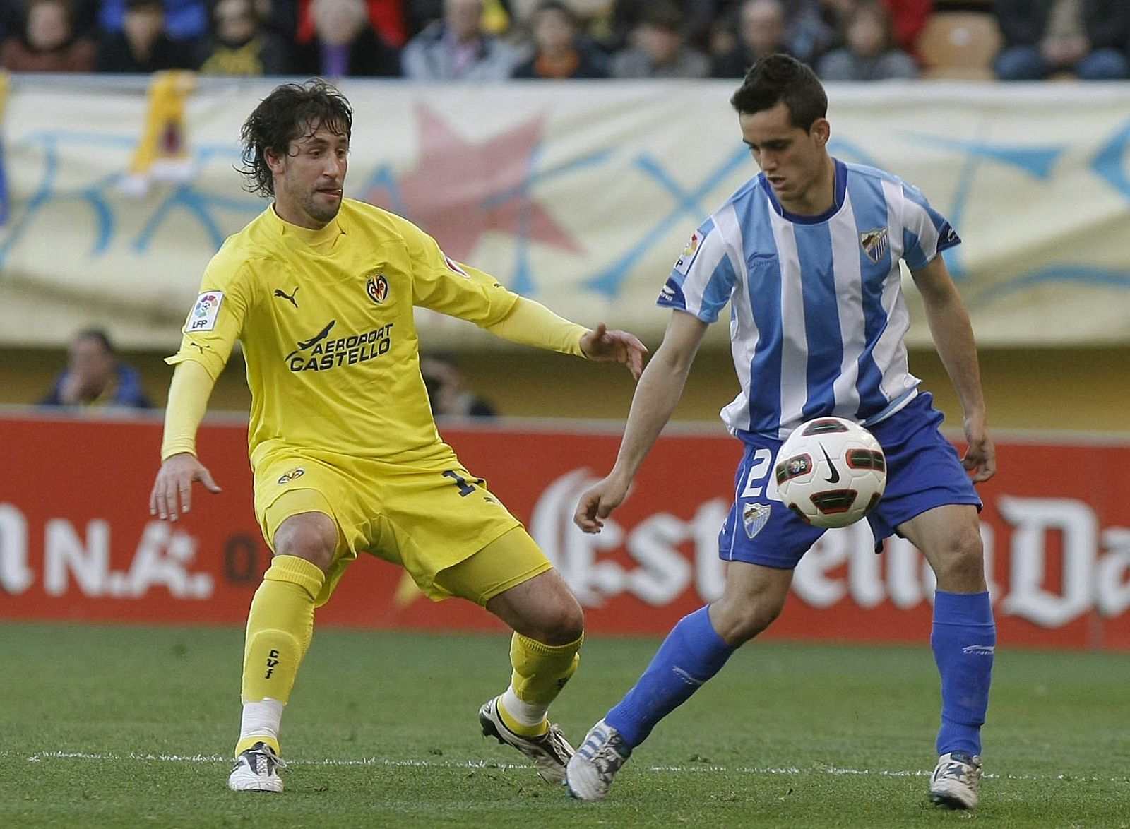 Joan Capdevila (i) pugna por el balón con el delantero del Málaga CF Juanmi Jiménez