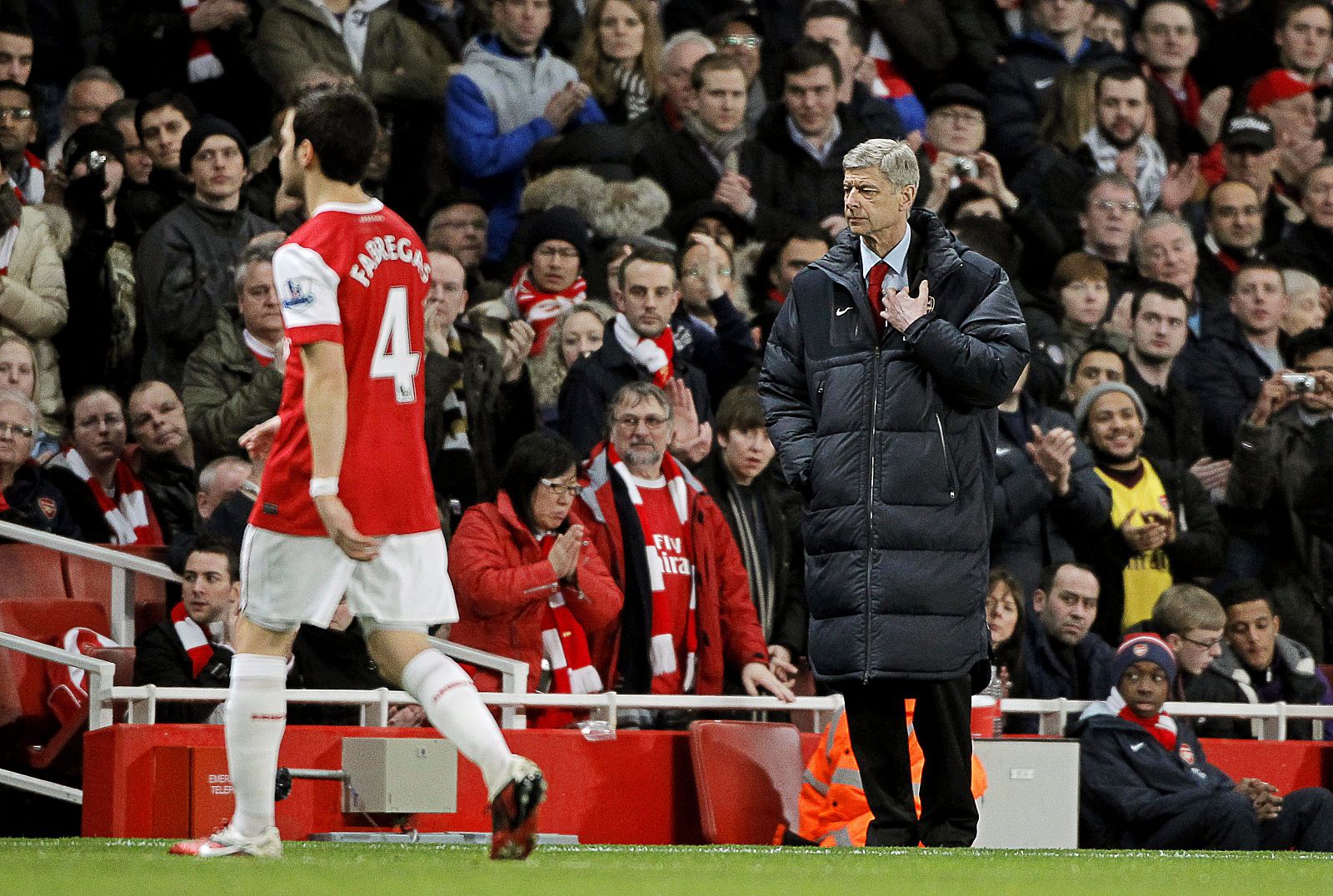 Cesc Fábregas abandona el terreno de juego bajo la mirada de su técnico Wenger durante un partido de la Premier