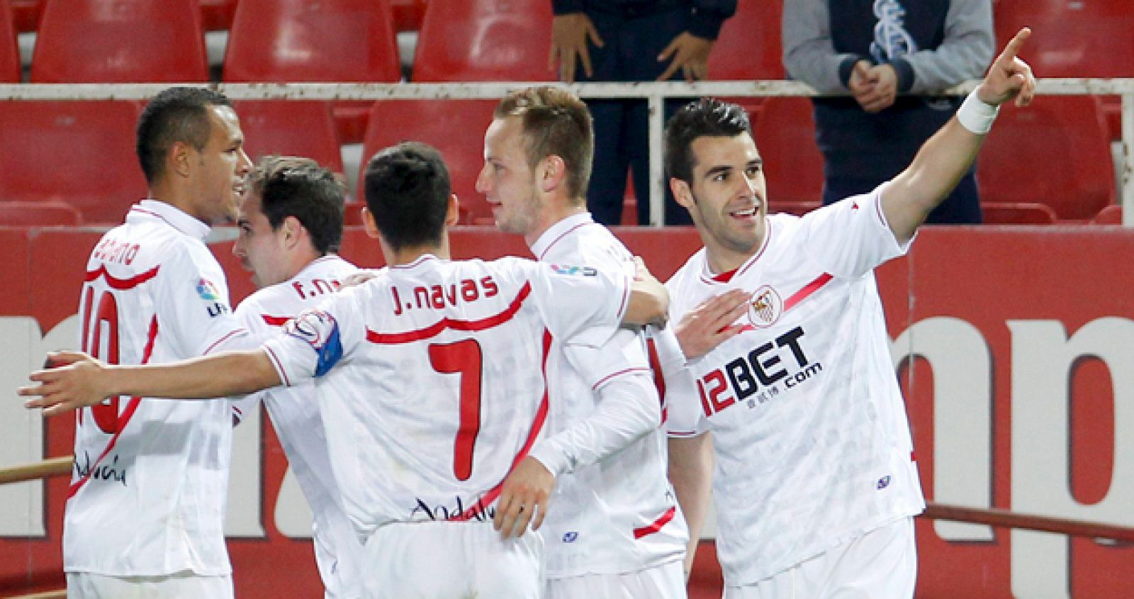 El delantero del Sevilla CF, Álvaro Negredo (d), celebra un gol con sus compañeros y la afición.