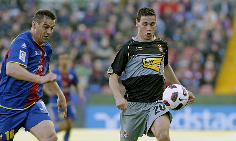 El delantero del RCD Espanyol, Álvaro Vázquez controla el balón ante el defensa del Levante Sergio Martínez Ballesteros.