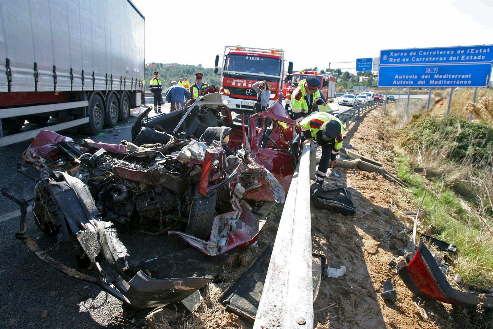 Los Bomberos de la Generalitat y los Mossos d'Esquadra inspeccionan el estado en el que han quedado los vehículos implicados en un choque frontal que ha costado la vida a los cuatro ocupantes del turismo