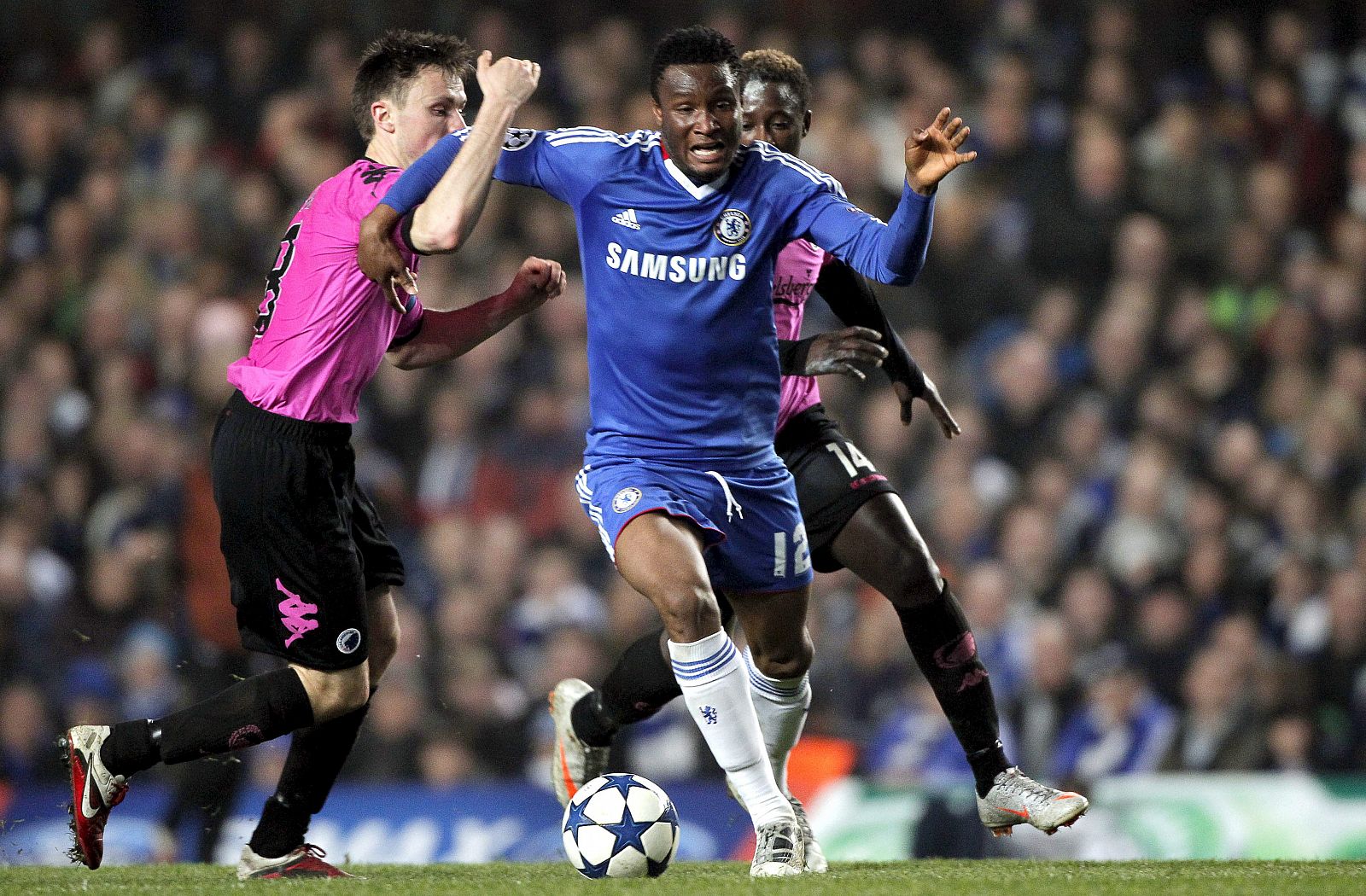 El jugador del Chelsea Obi Mikel intenta controlar el balón entre William Kvist y Dame N'Doye, del FC Copenhague.