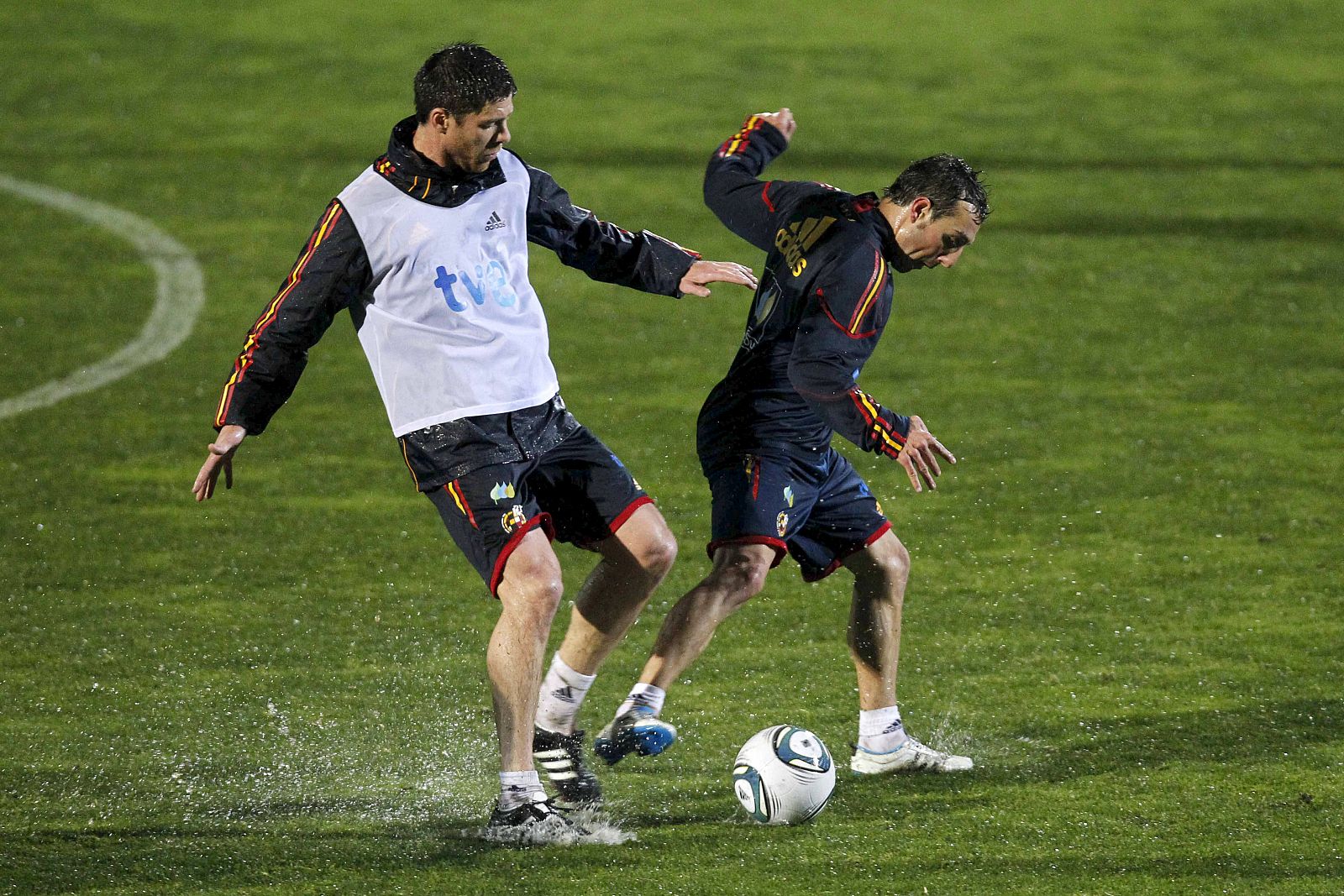 Santi Cazorla, en un entrenamiento con la selección, forcejea con Xabi Alonso.