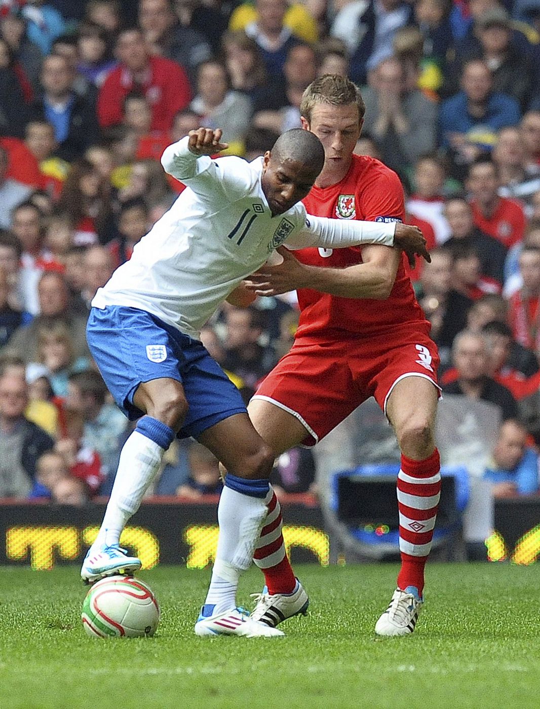 El inglés Ashley Young lucha por el control del balón con Danny Collins de Gales.