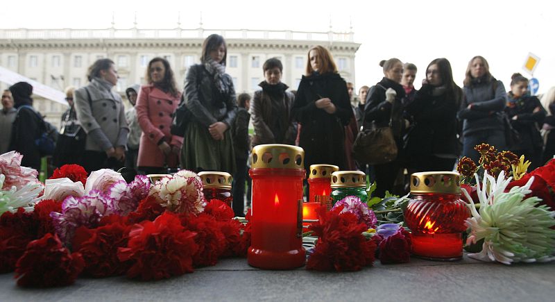 Un grupo de personas deja flores ante la estación de metro de Oktyabrskaya, en Minsk