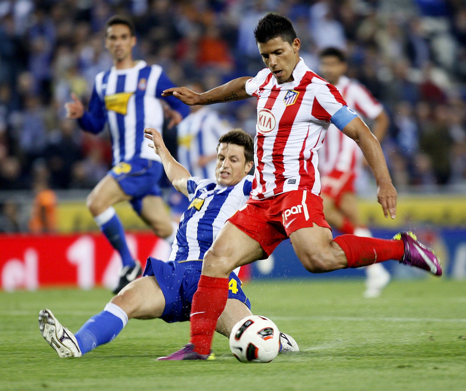 Sergio "Kun" Agüero se dispone a chutar a puerta ante la entrada del defensa del RCD Espanyol Ernesto Galán.