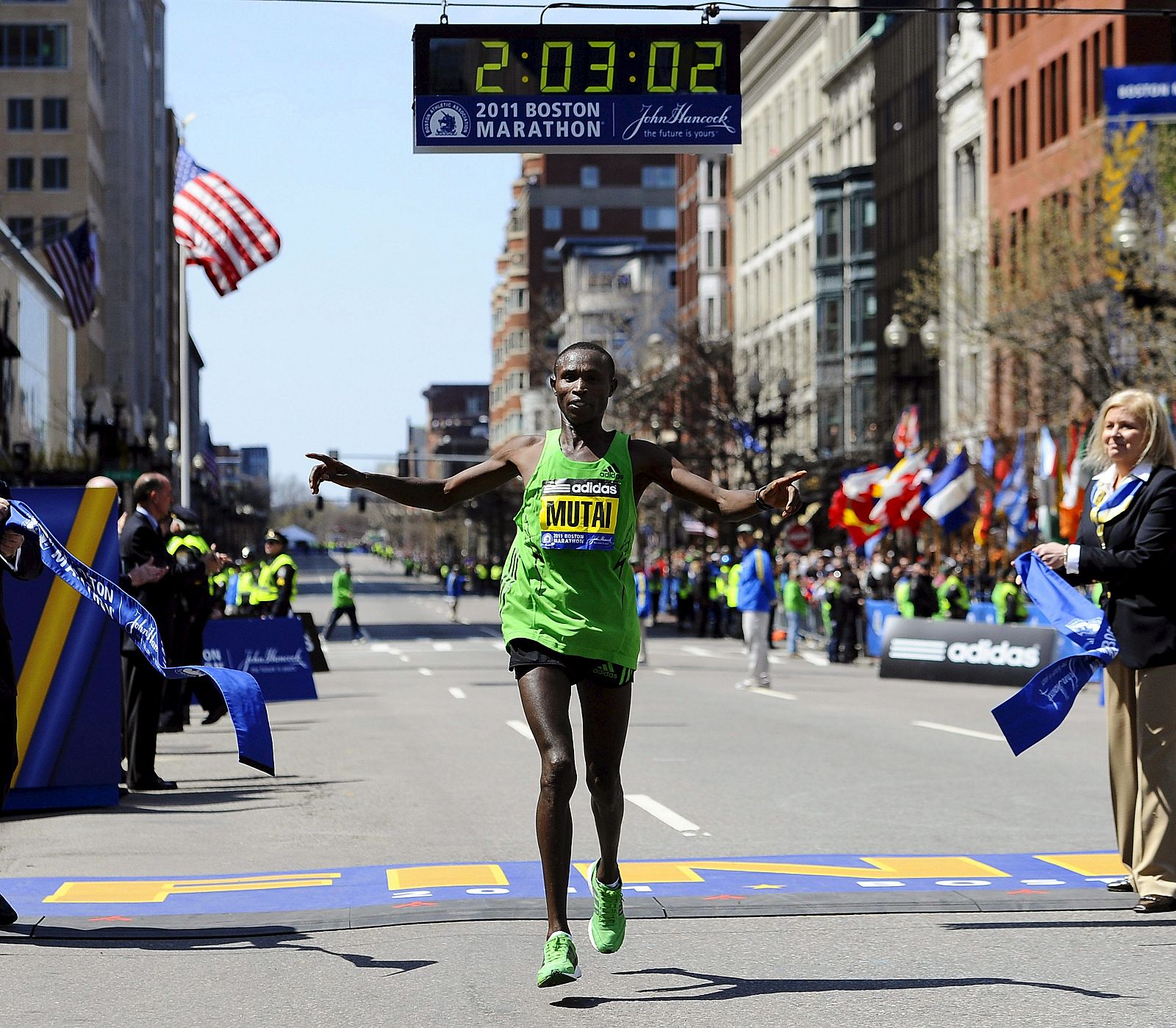 Momento en que Mutai cruza la meta de Boston con su récord reflejado en la parte superior