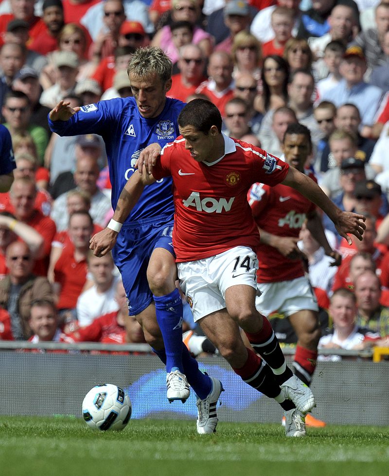 Hernández, del United, disputa el balón con Phil Neville, del Everton