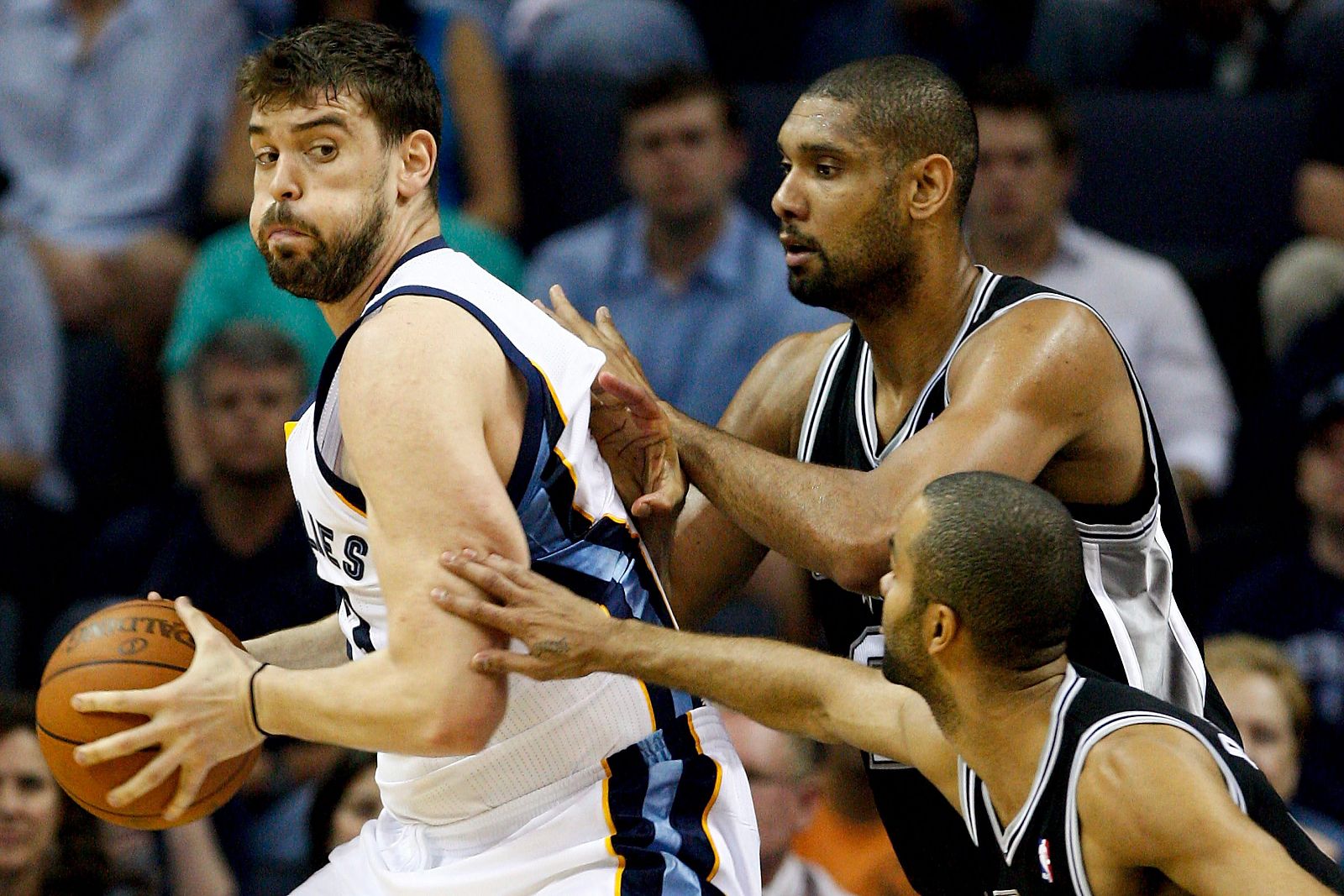 El jugador de los Grizzlies Marc Gasol lucha por el balón con Tony Parker y Tim Duncan de los Spurs.