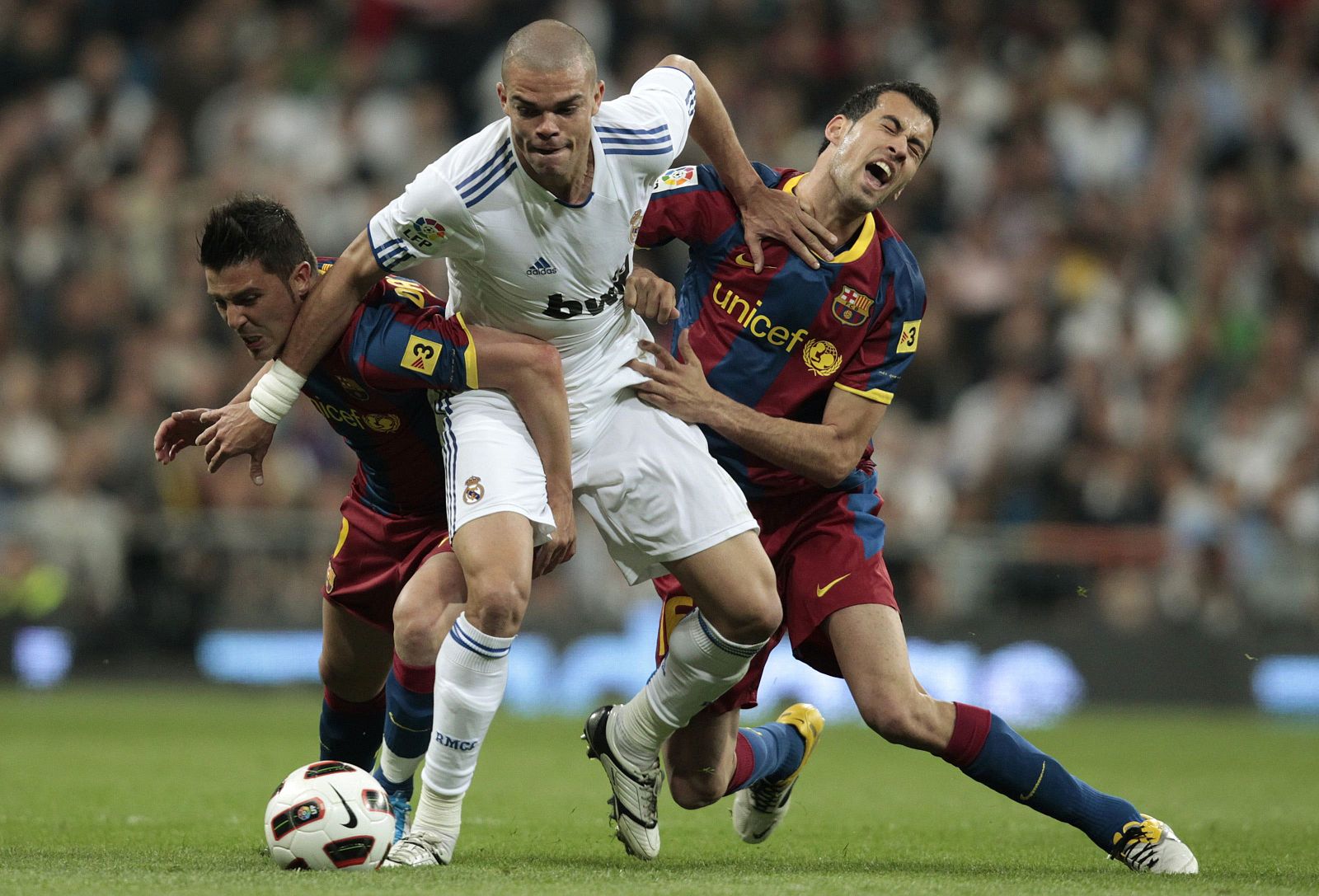 Real Madrid's  Pepe is challenged by Barcelona's Villa and Busquets during their Spanish first division soccer match in Madrid