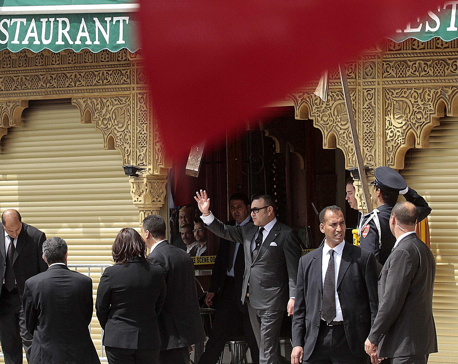 Morocco's King Mohamed waves to the crowd after visiting at the site of the April 28 blast in Marrakesh