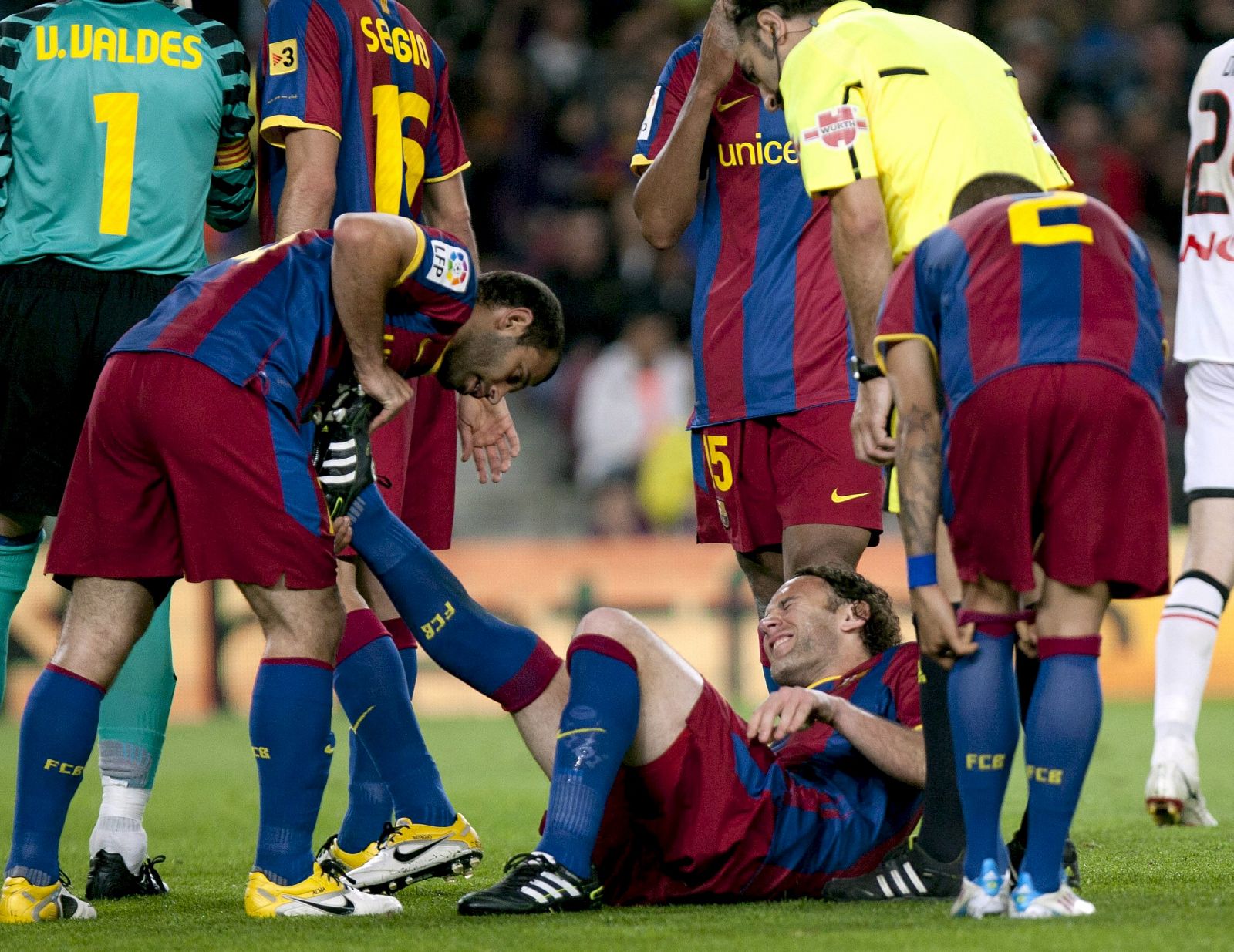 El defensa argentino del FC Barcelona Gabriel Milito atendido por sus compañeros.