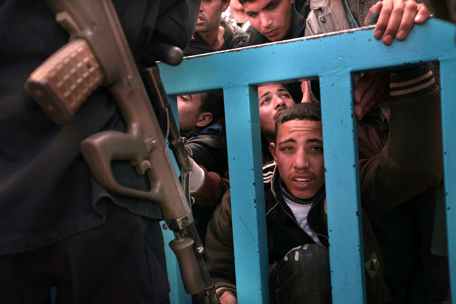 Un militar tunecino intentando sostener la avalancha de trabajadores inmigrantes procedentes de Libia en el puesto de Ras Jadir en Túnez, el 4 de marzo