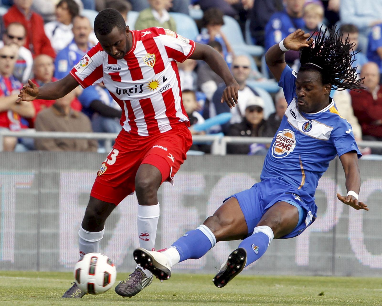 El mediocentro del Getafe, Boateng (d), lucha por el balón con el delantero del Almería, Goitom