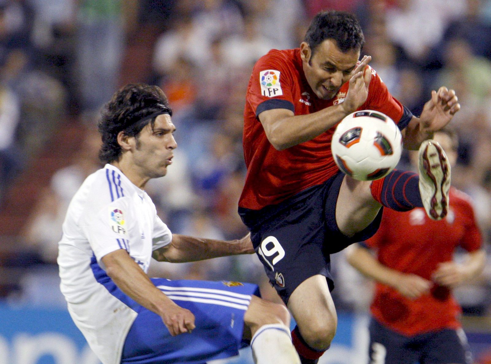 El centrocampista del Real Zaragoza Ángel Lafita pugna por el balón con el centrocampista de Osasuna Javier Calleja.