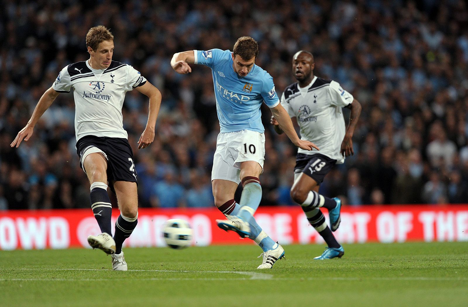 El jugador del Manchester City Edin Dzeko disputa el balón con Michael Dawson del Tottenham Hotspur.