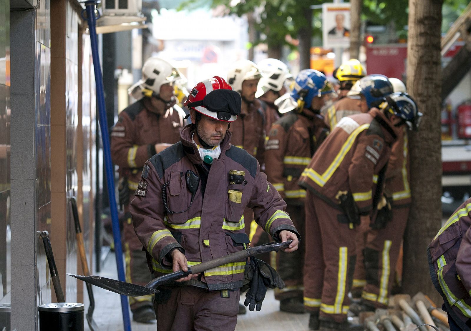 Bomberos y otros equipos de emergencias intentan rescatar a una anciana de 83 años que ha quedado atrapada bajo los escombros de un inmueble derrumbado