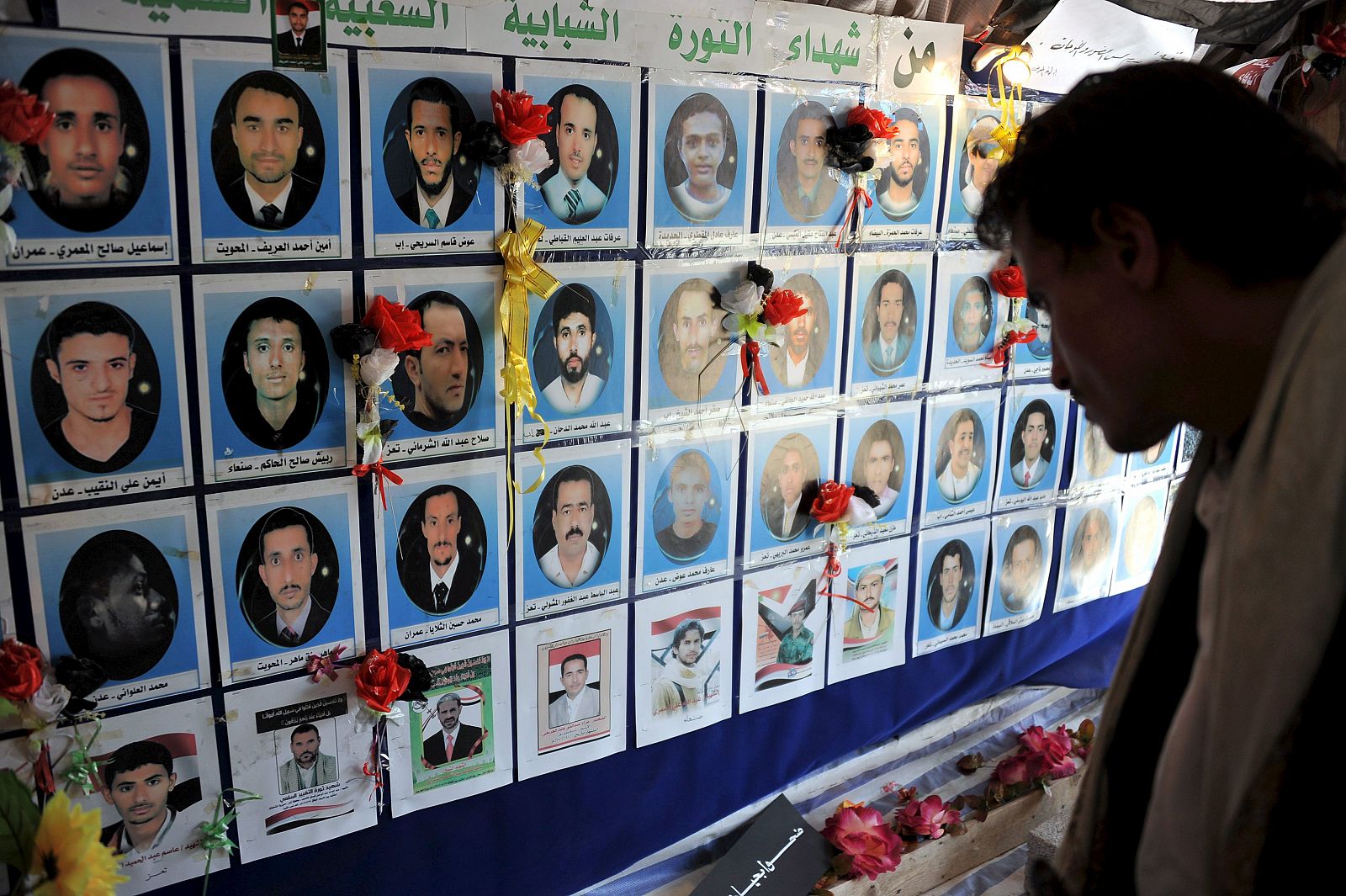 Un manifestante antigubernamental observa las fotografías de los protestantes asesinados por las fuerzas de seguridad durante una protesta política en Saná, Yemen, el 12 de mayo de 2011