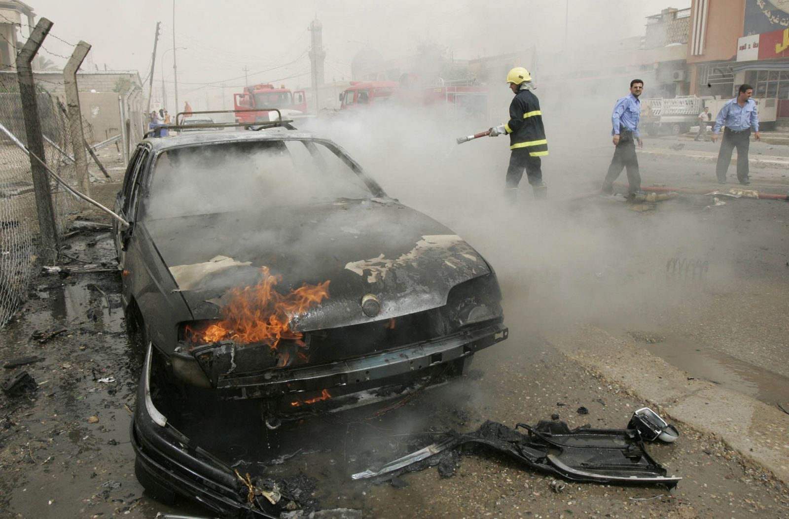 Los bomberos intentan apagar las llamas en uno de los vehículos incendiados en el atentado de Kirkuk