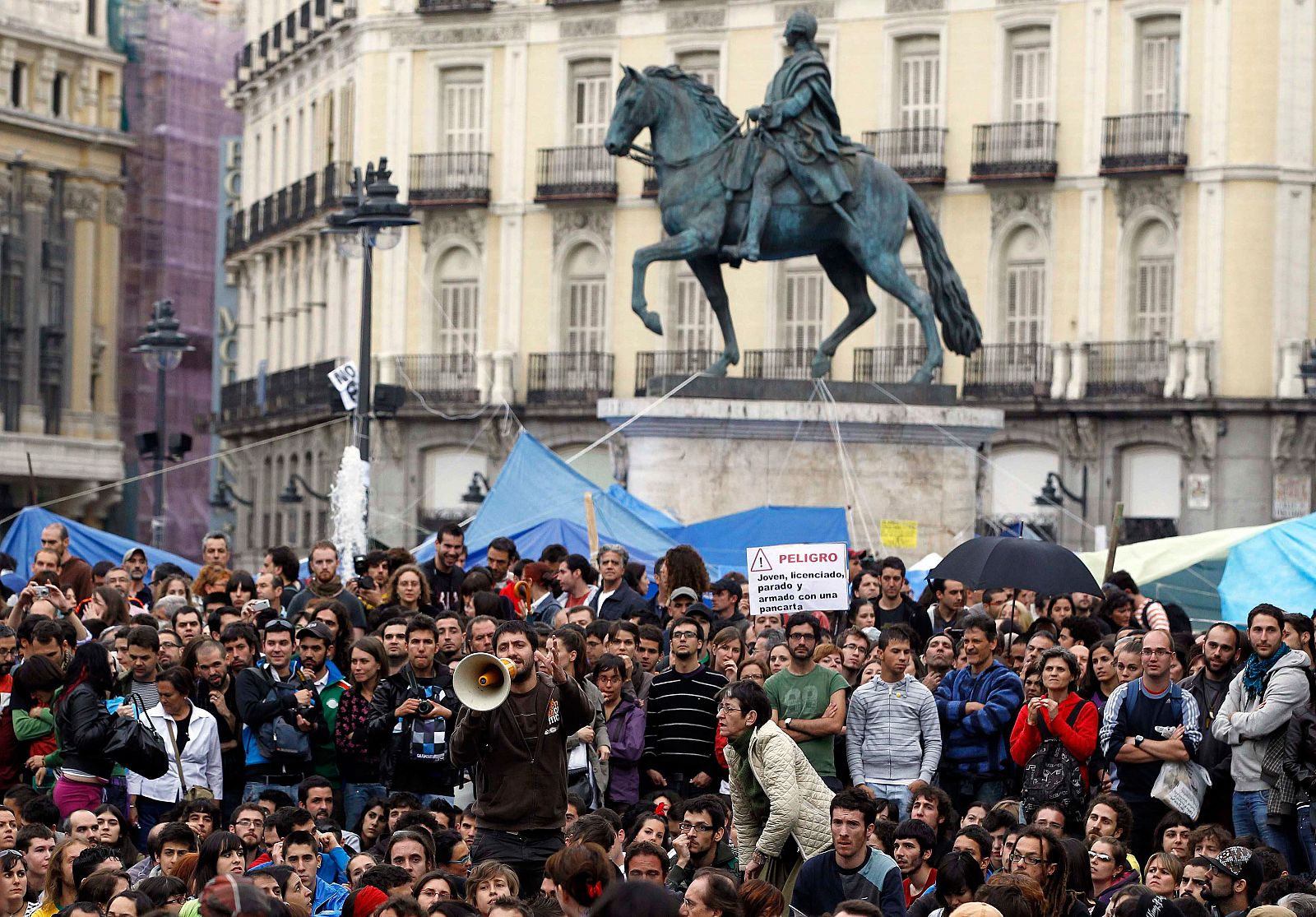 Manifestantes escuchan a los portavoces del movimiento 15-M