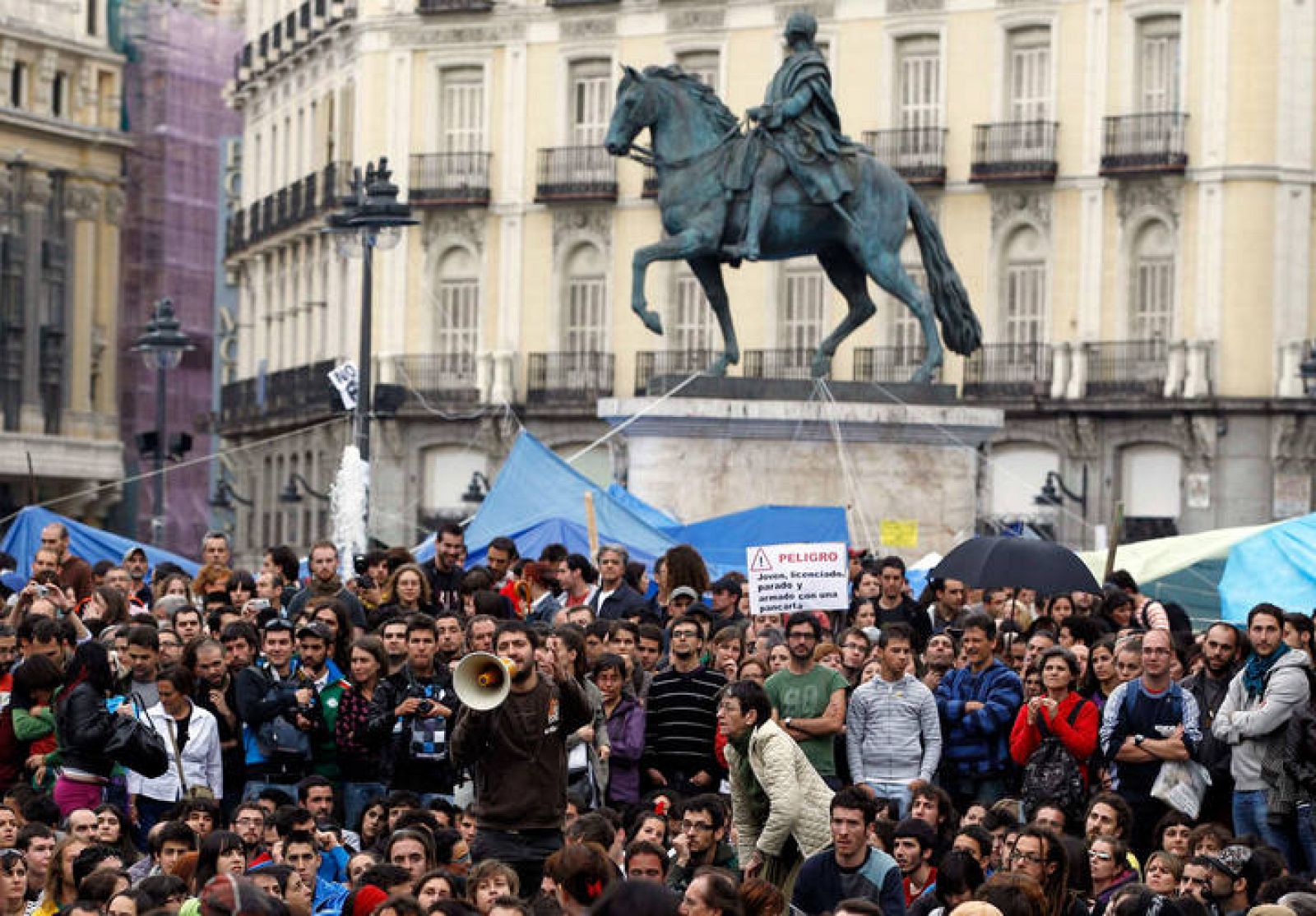 Manifestantes escuchan a los portavoces del movimiento 15-M 