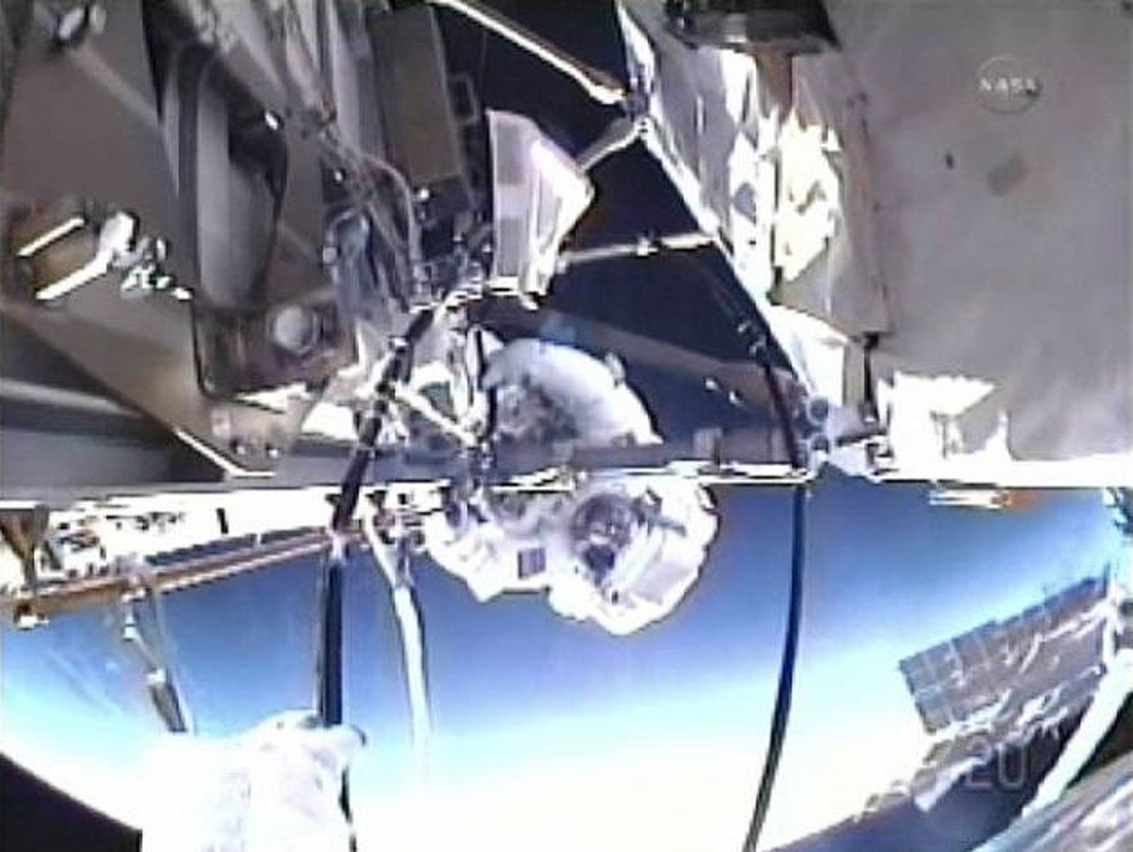 A view from Mike Fincke's helmet camera gives a close-up view of Andrew Feustel backdropped against the Earth during their spacewalk in this image from NASA TV