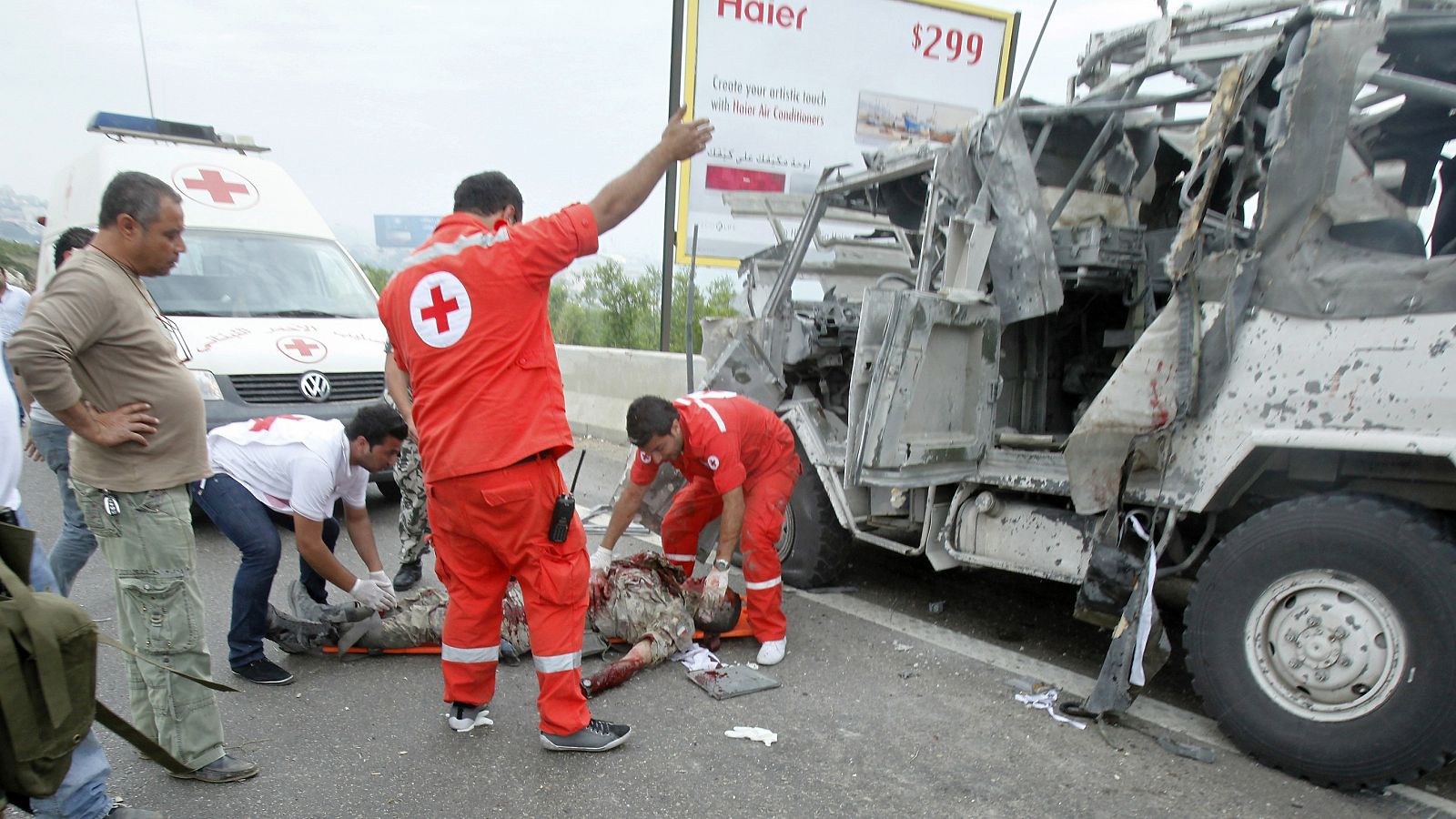 Miembros de la Cruz Roja ayudan a un soldado italiano herido en el atentado.