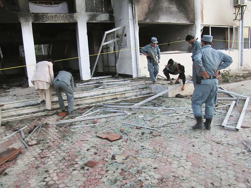 Afghan policemen inspect the outside of the governor office in Takhar province