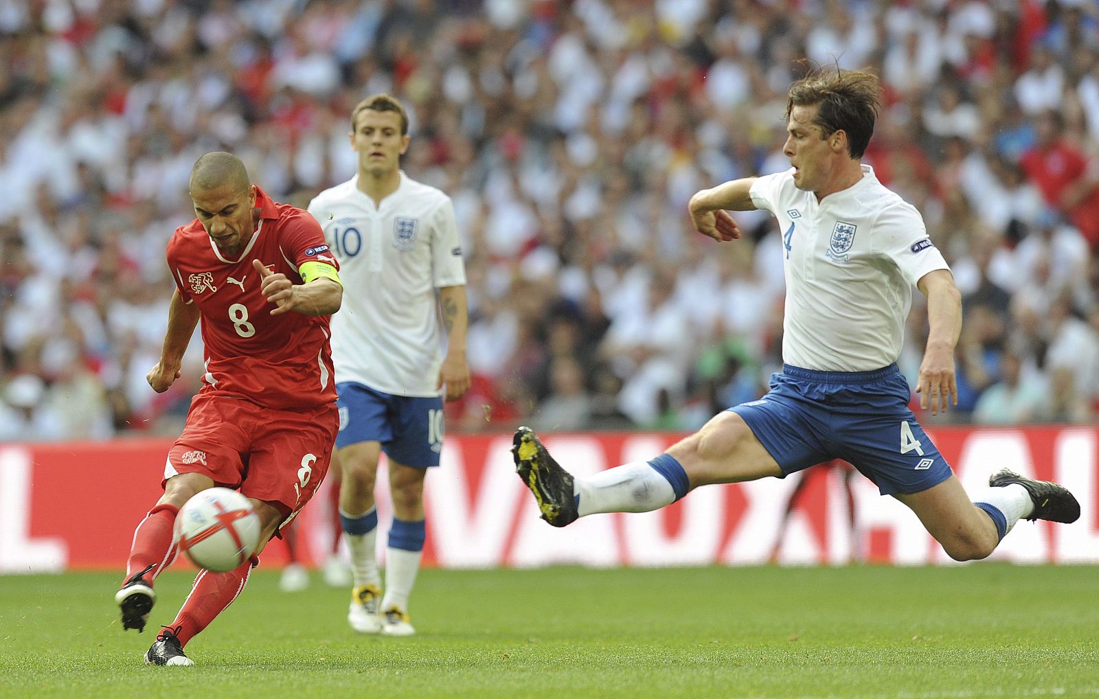 El capitán de la selección suiza, Gokhan Inler (i), intenta marcar un gol durante el partido contra Inglaterra