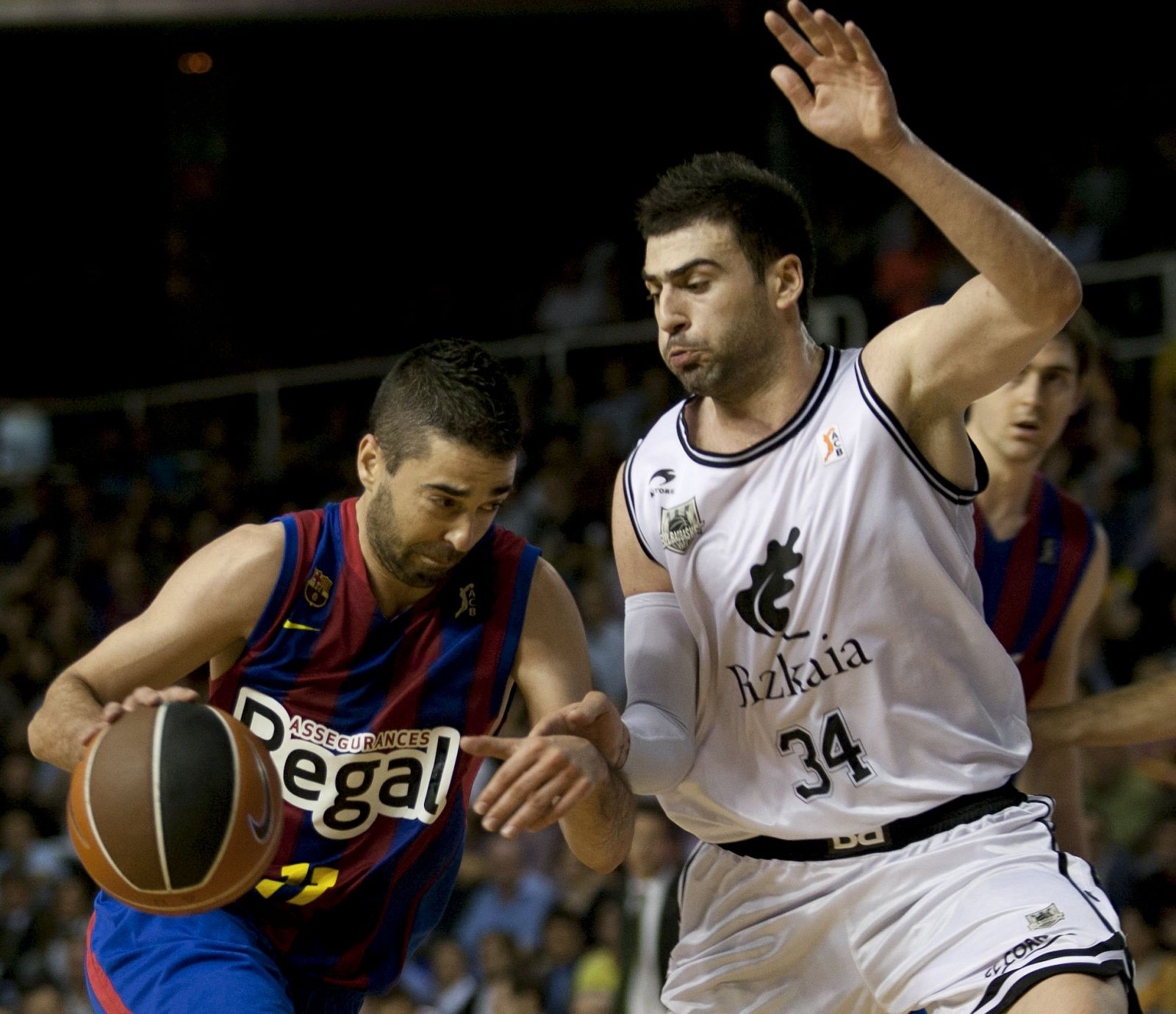 El escolta del Regal FC Barcelona Juan Carlos Navarro avanza con el balón ante el alero griego del Bizkaia Bilbao Basket Kostas Vasileiadis.