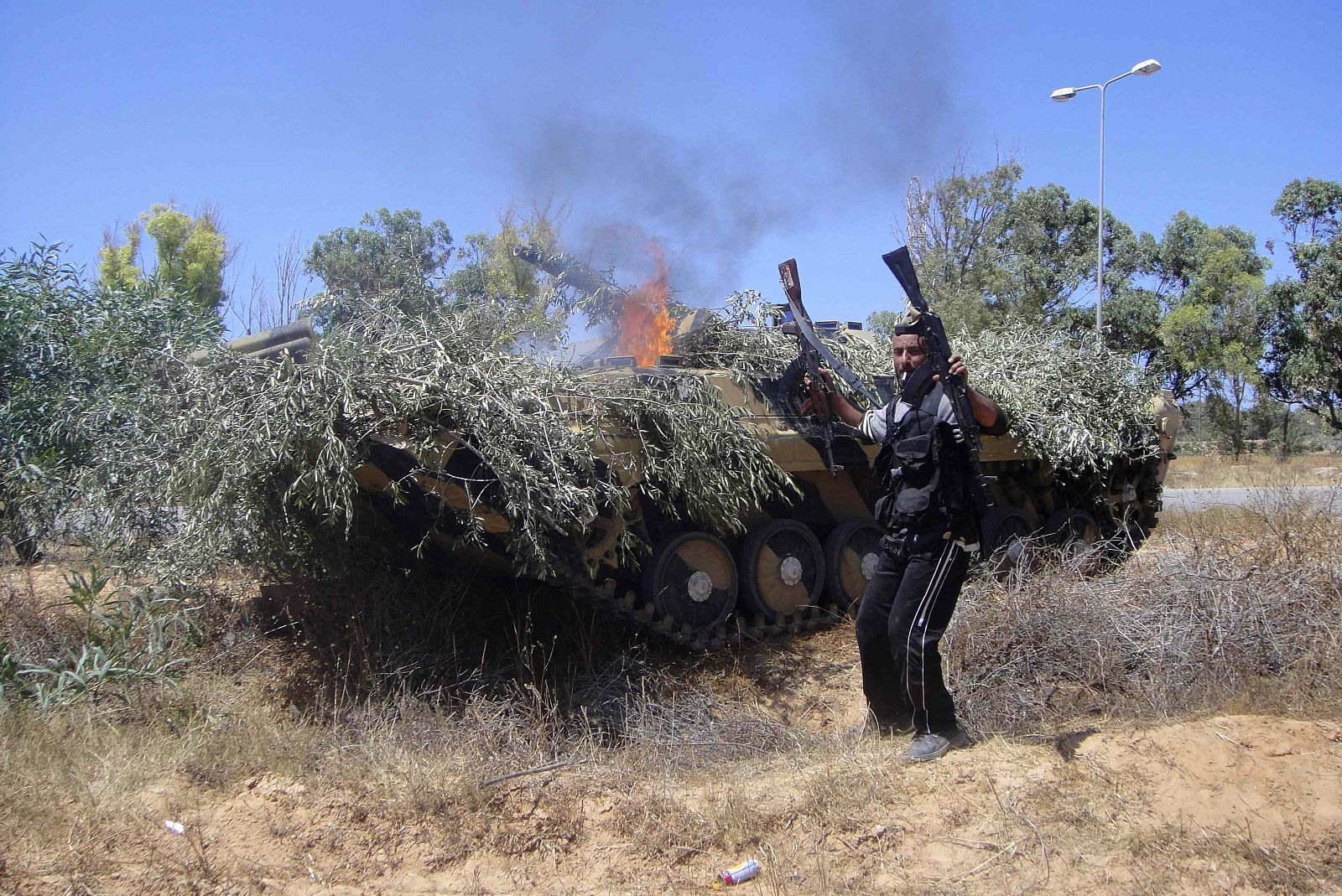 Rebels set fire to an APC captured from forces loyal to Libyan leader Muammar Gaddafi on the outskirts of the town of Zlitan